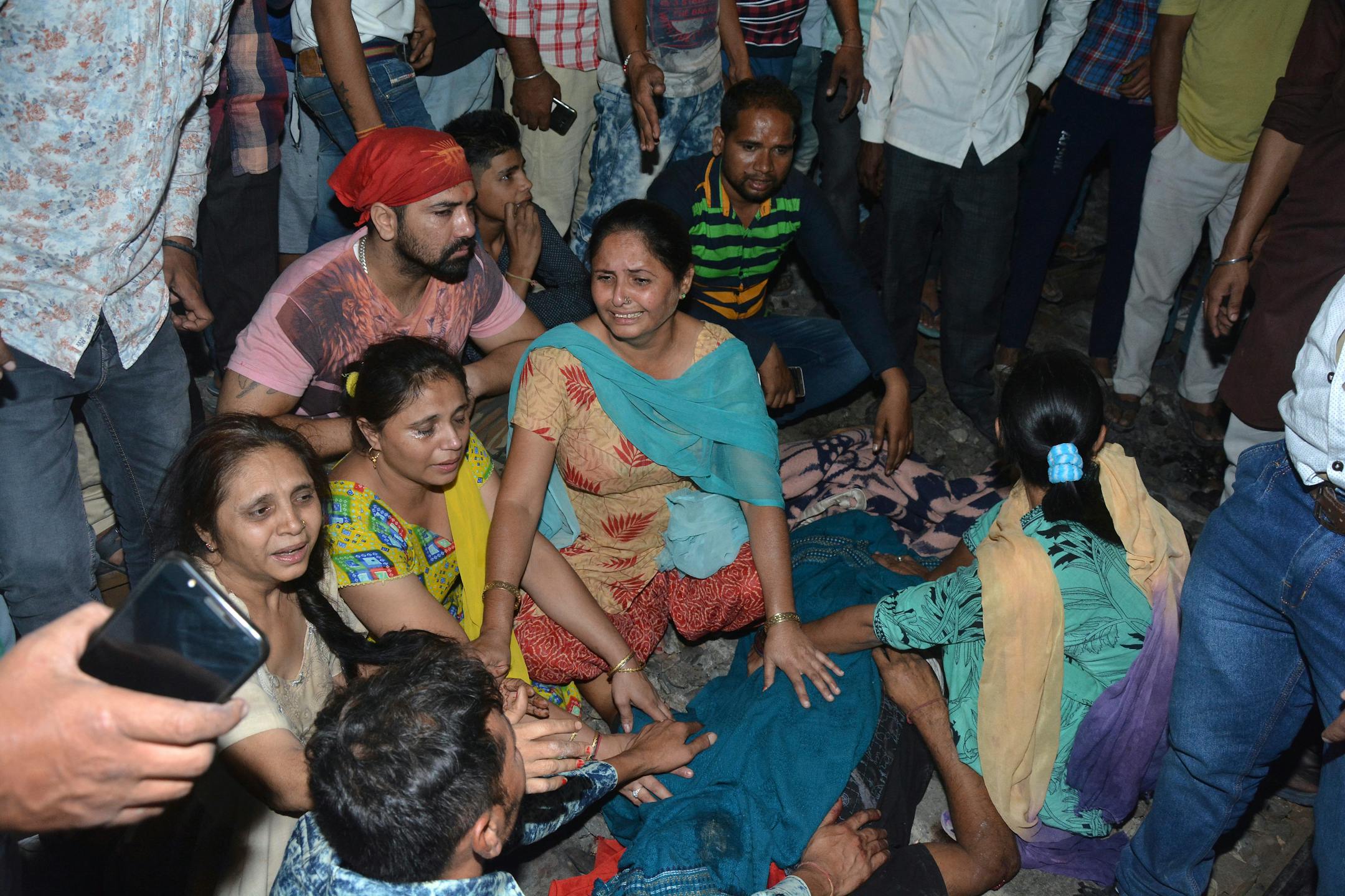 Relatives mourn by the body of a victim of a train accident in Amritsar, India, Friday, Oct. 19, 2018. A speeding train ran over a crowd watching fireworks during a religious festival in northern India on Friday, killing at least 50 people, a Congress party leader said.