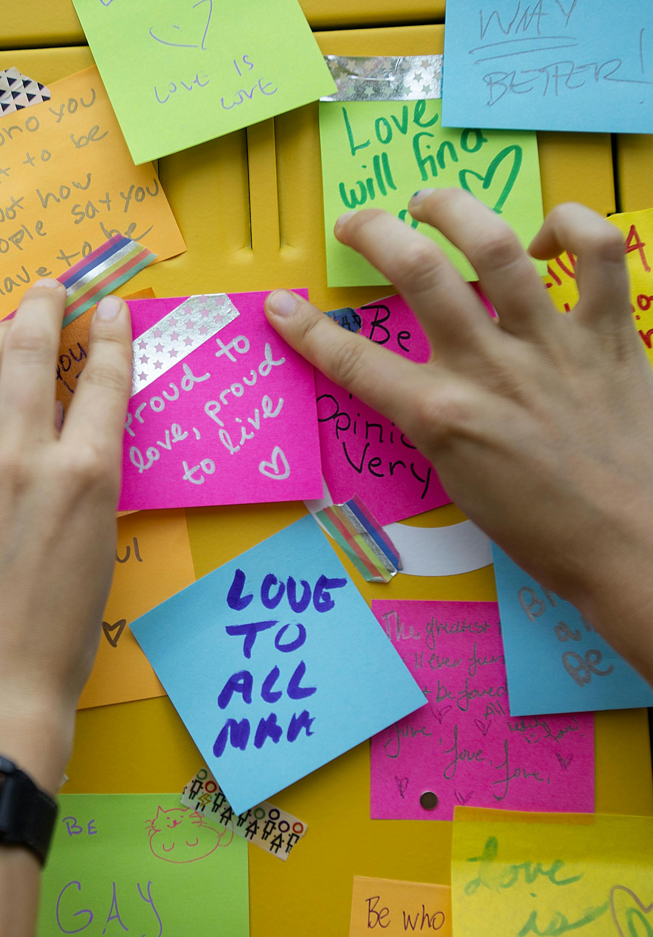 Kaia Findlay places a sticky note with her motivational words "proud to love, proud to live," on lockers set up by Target at the pride festival on Saturday. ] ALEX KORMANN • alex.kormann@startribune.com The Twin Cities celebrated love and all it's forms with the Minneapolis Pride Festival in Loring Park on Saturday June 23, 2018. Thousands gathered in the park for a variety of festivities including performances by members of the Imperial Court of Minnesota, vendors, games and giveaways. T