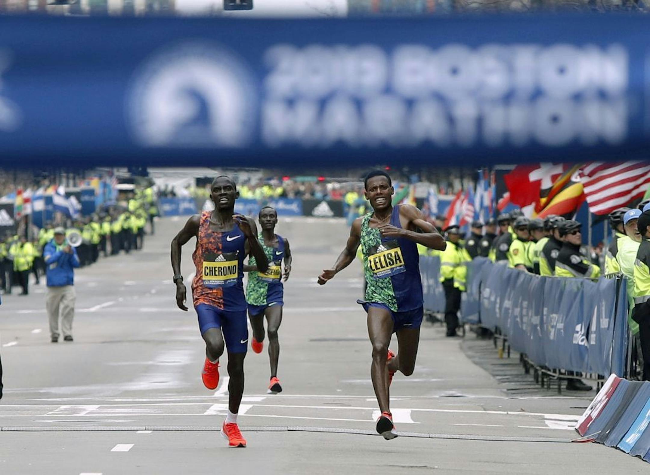 Lawrence Cherono, left, of Kenya, runs to the finish line to win the 123rd Boston Marathon in front of Lelisa Desisa, of Ethiopia, right, on Monday, April 15, 2019, in Boston.