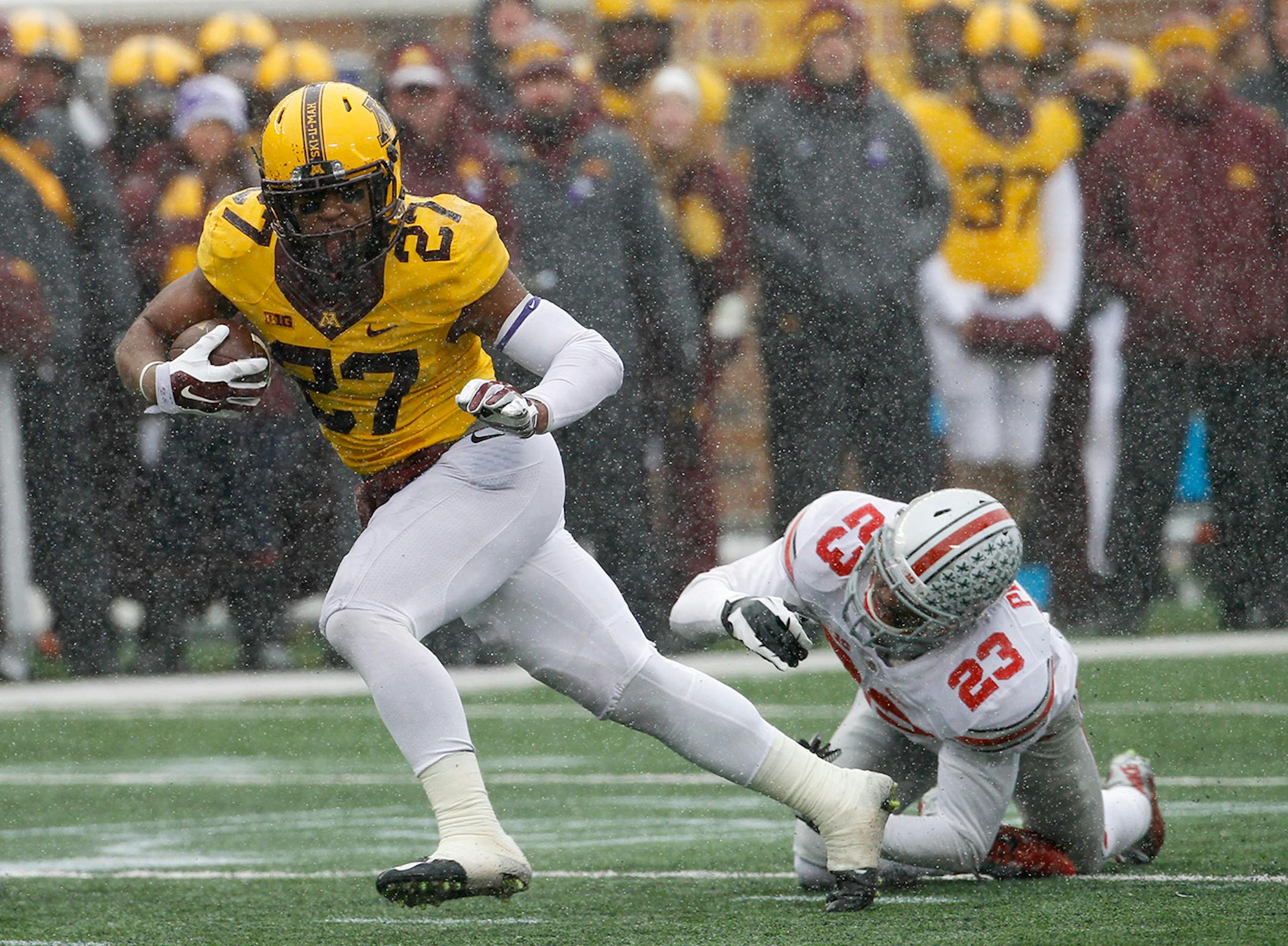 Minnesota running back David Cobb (27) leaves behind Ohio State safety Tyvis Powell on a 30-yard touchdown during the second quarter of an NCAA college football game in Minneapolis Saturday, Nov. 15, 2014. (AP Photo/Ann Heisenfelt)