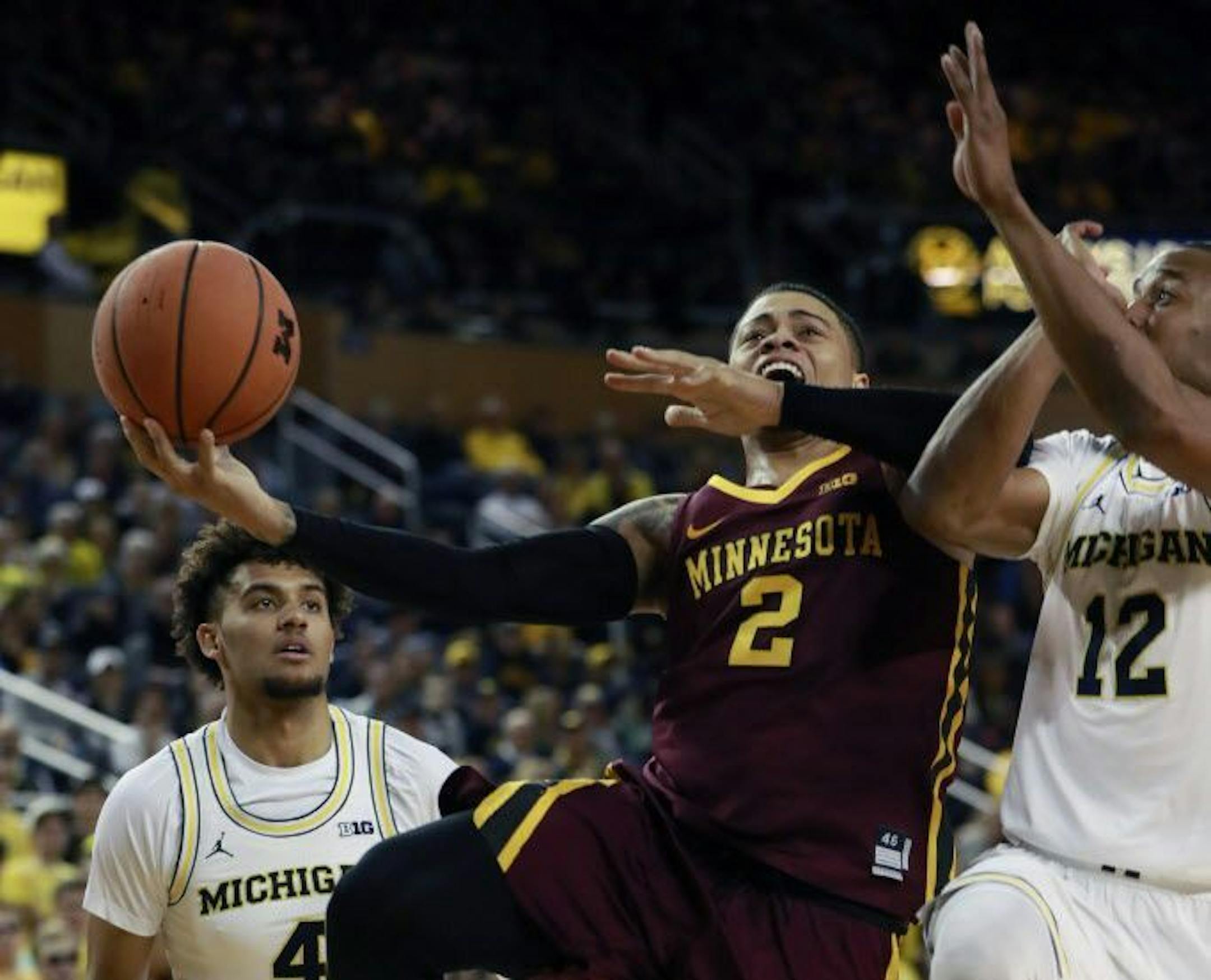 Minnesota guard Nate Mason (2) makes a lamp as Michigan guard Muhammad-Ali Abdur-Rahkman (12) defends during the first half of an NCAA college basketball game, Saturday, Feb. 3,2018, in Ann Arbor, Mich.