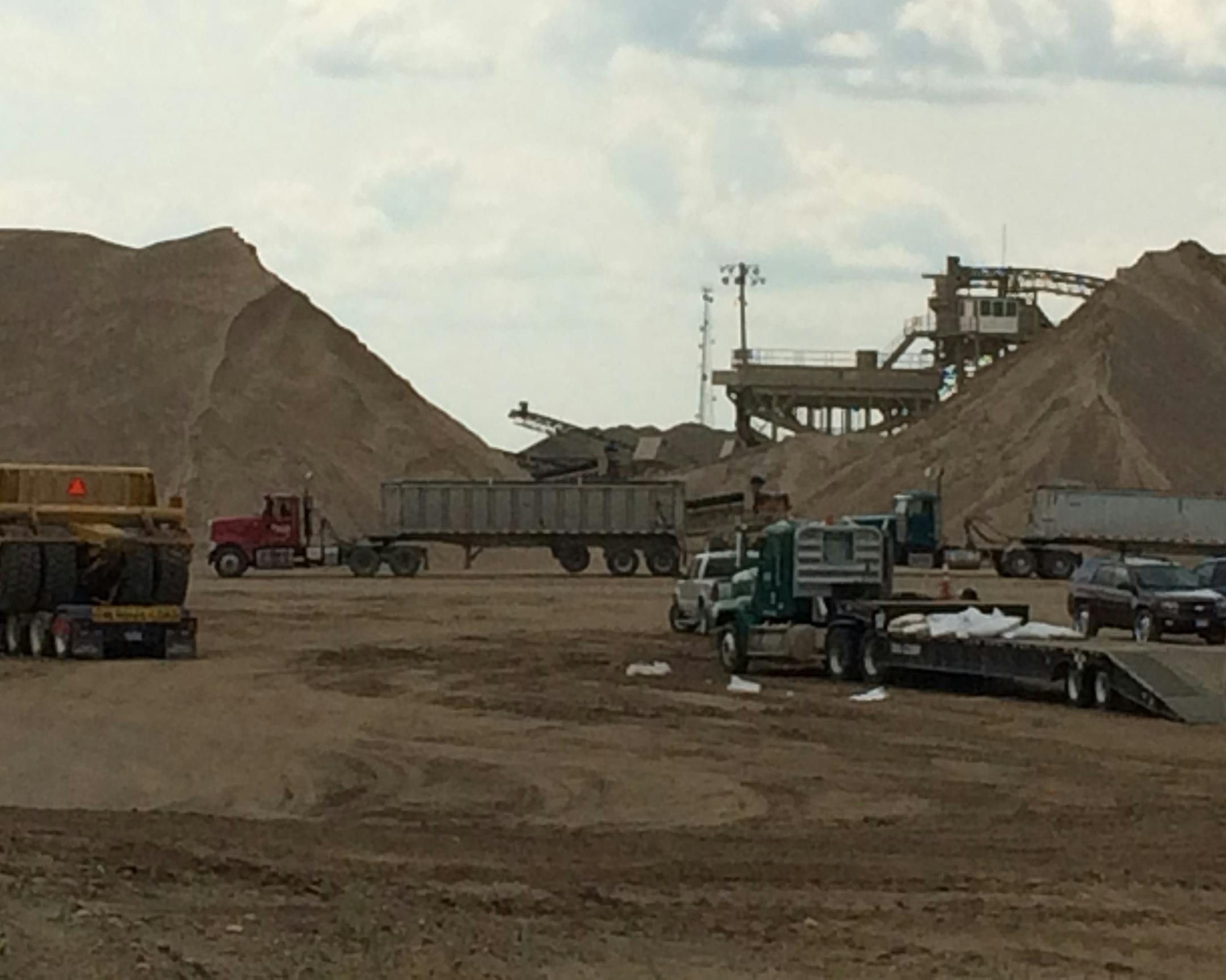 Huge piles of sand loom over heavy machinery at the Dakota Aggregates mine at UMore Park, the University of Minnesota's property near Rosemount.