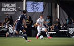 Minnesota United midfielder Hassani Dotson controls a ball in front of Sporting Kansas City defender Roberto Puncec