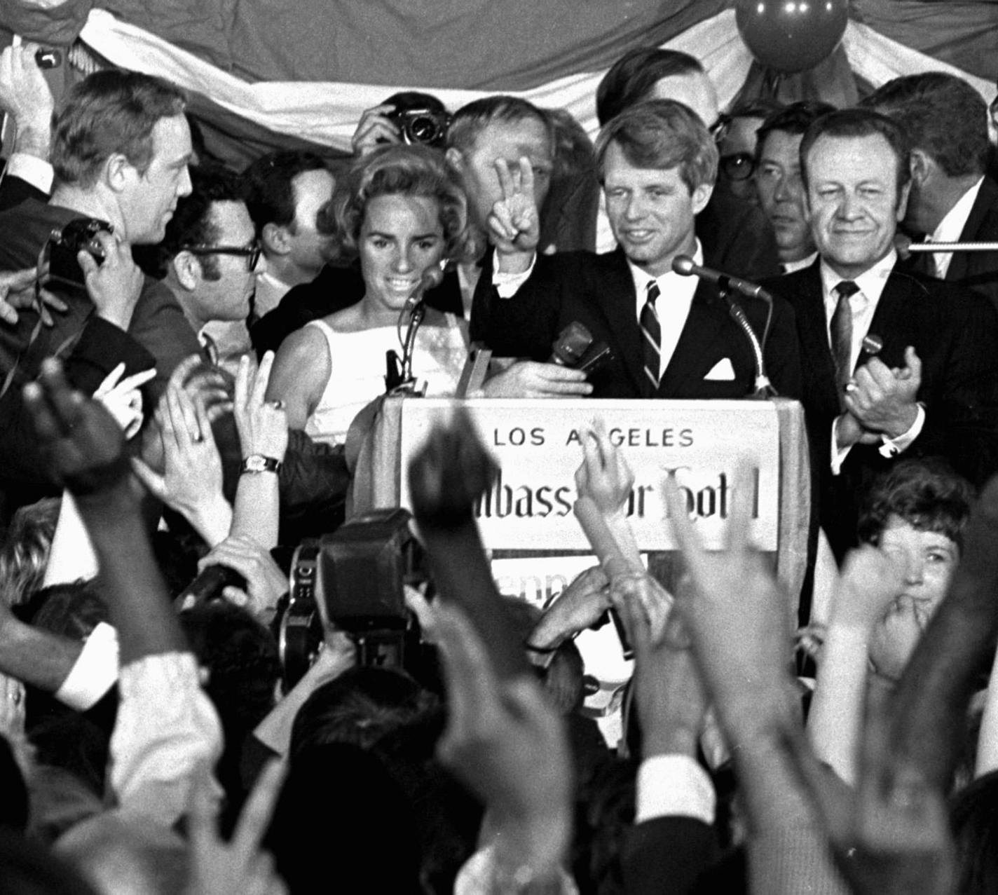 FILE - This June 5, 1968 file photo shows Sen. Robert F. Kennedy speaking his final words to supporters at the Ambassador Hotel in Los Angeles, moments before he was shot on June 5, 1968. At his side are his wife, Ethel, left, and his California campaign manager, Jesse Unruh, right. Football player Roosevelt Grier is at right rear. Associated Press Hollywood reporter Bob Thomas was on a one-night political assignment in June 1968 to cover Kennedy&#xed;s victory in the California presidential pri