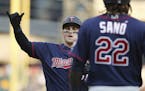 Minnesota Twins designated hitter Tyler Austin, left, approaches home plate after hitting a two-run home run that also scored Miguel Sano (22) during 