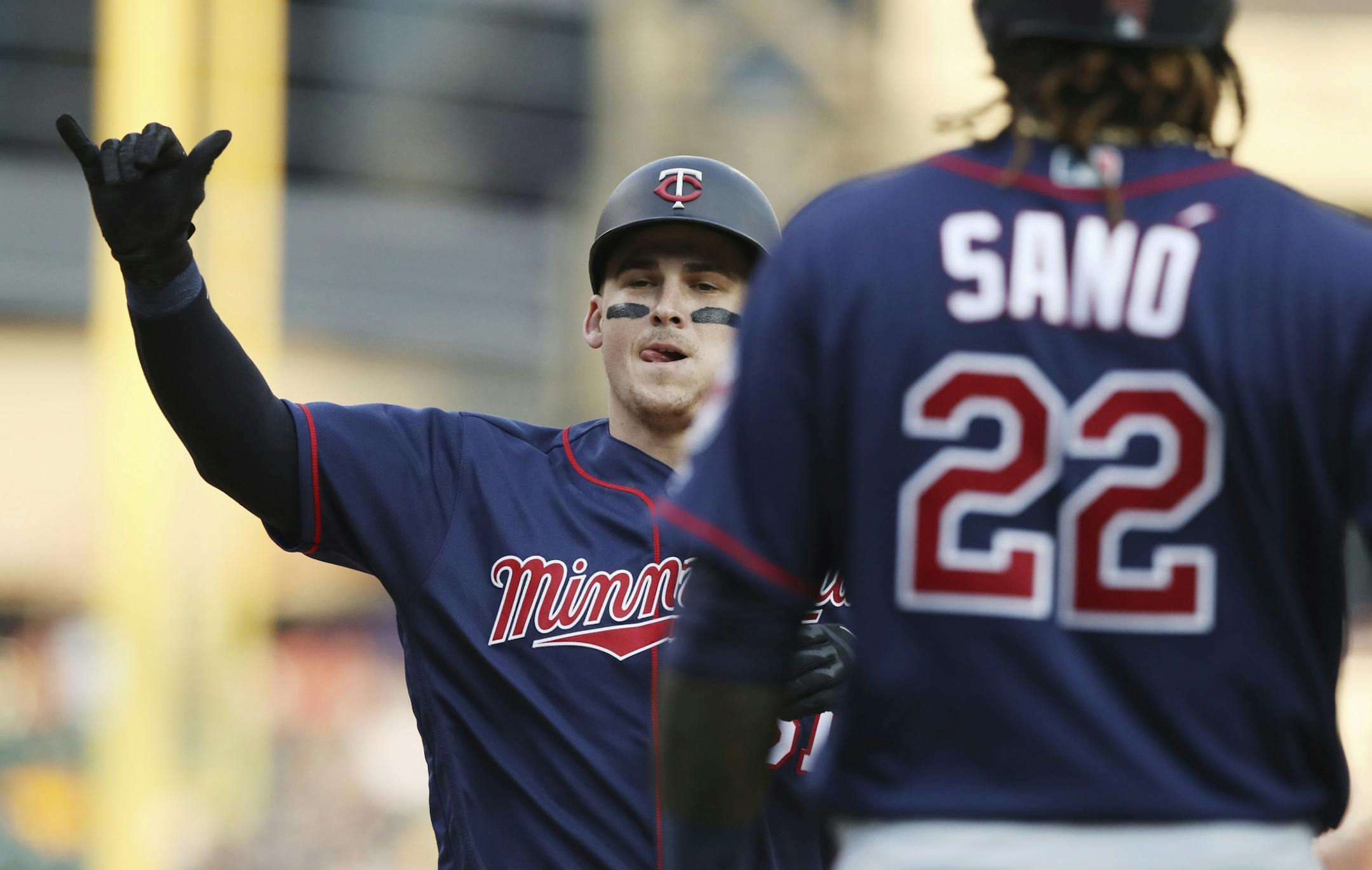 Minnesota Twins designated hitter Tyler Austin, left, approaches home plate after hitting a two-run home run that also scored Miguel Sano (22) during the fifth inning of a baseball game against the Detroit Tigers, Saturday, Aug. 11, 2018, in Detroit.