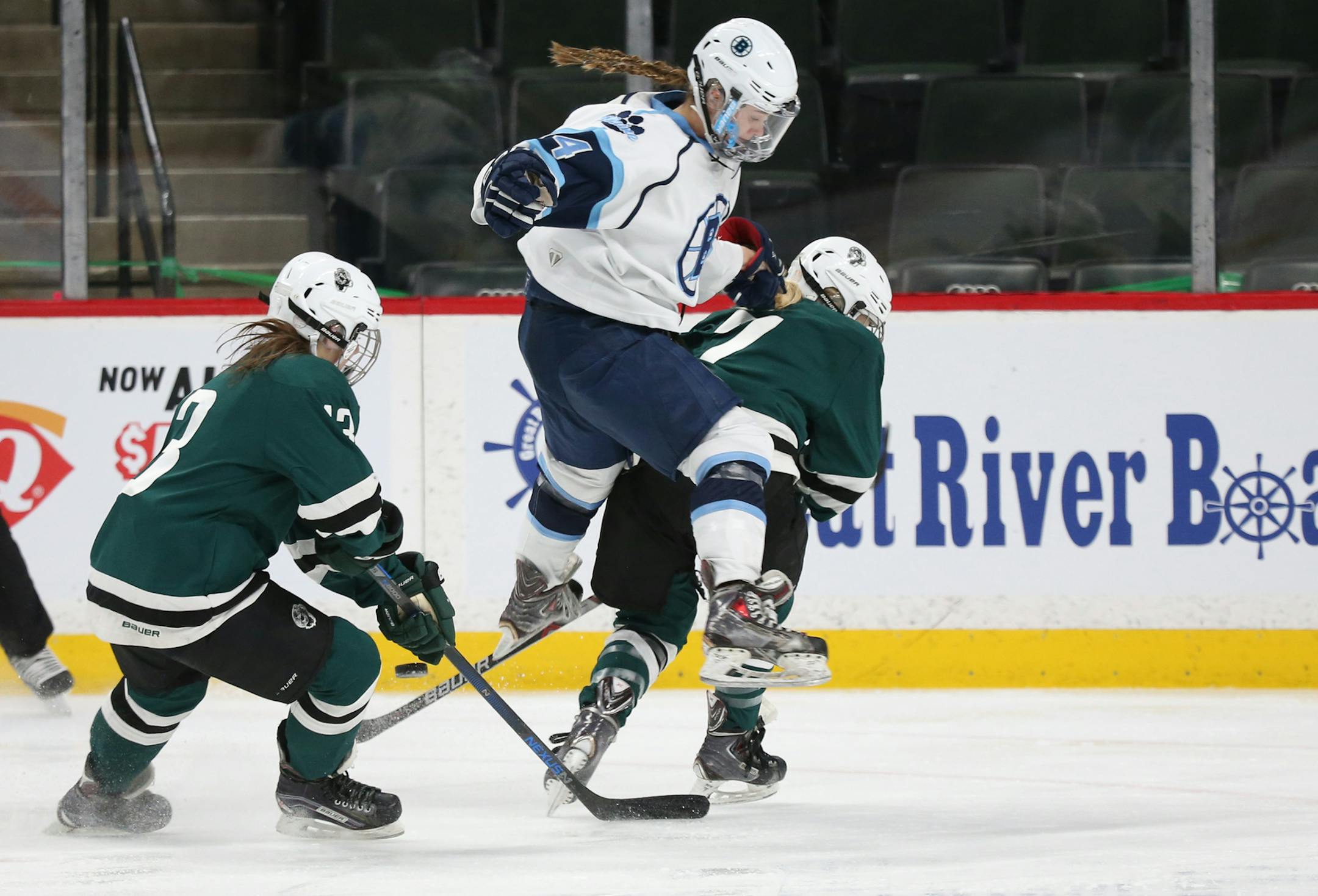 Blaine's Paige Beebe (14) leaped between two Roseau defenders to go after the puck during the first period. ] (KYNDELL HARKNESS/STAR TRIBUNE) kyndell.harkness@startribune.com Girls' hockey state tournament. Roseau vs. Blaine Thursday, Feb. 23, 2016 at the Xcel Energy Center in St. Paul, Min.