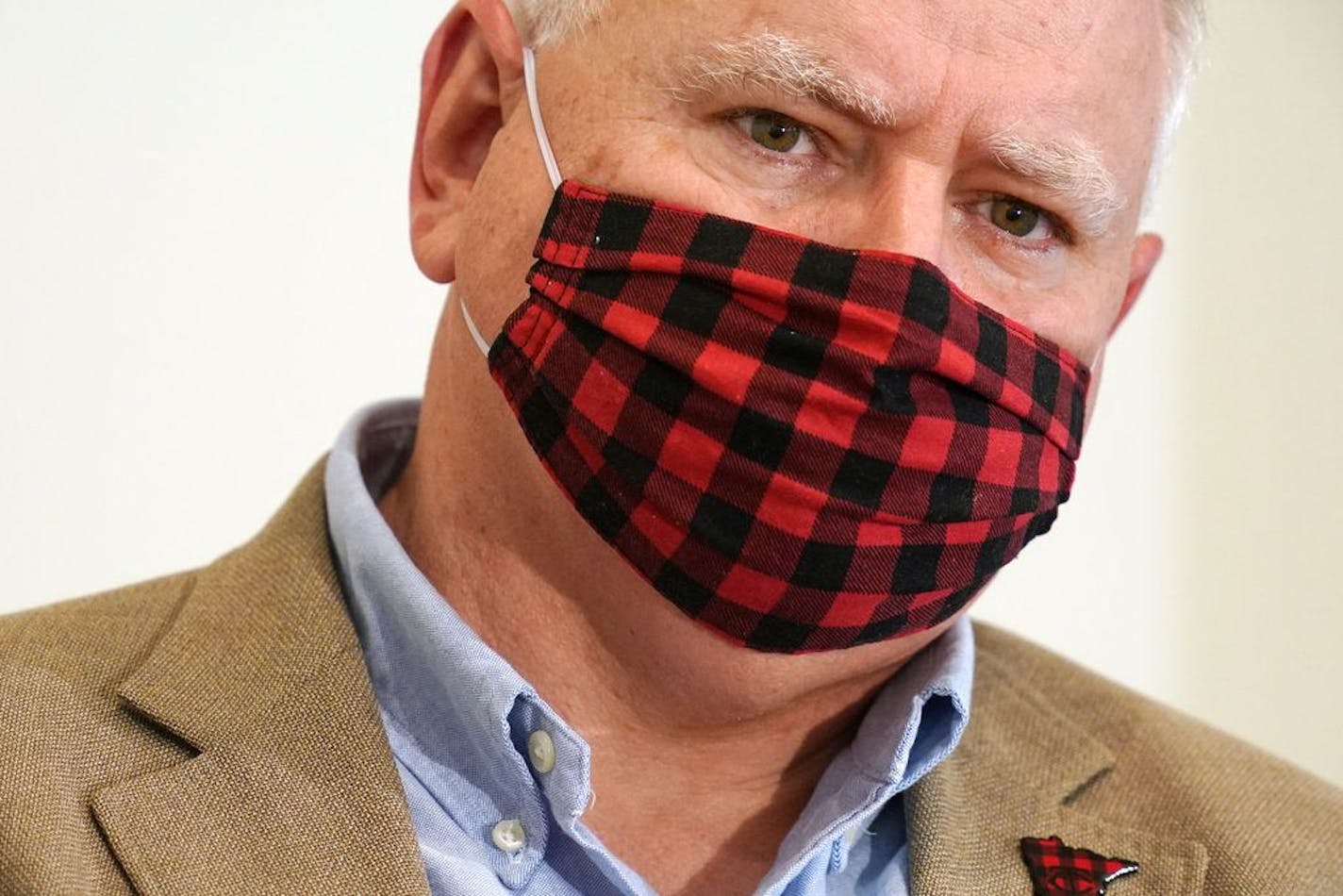 Gov. Tim Walz wore his buffalo plaid cloth mask during questions at a press conference to announce a statewide mask mandate to help slow the spread of COVID-19 Wednesday.