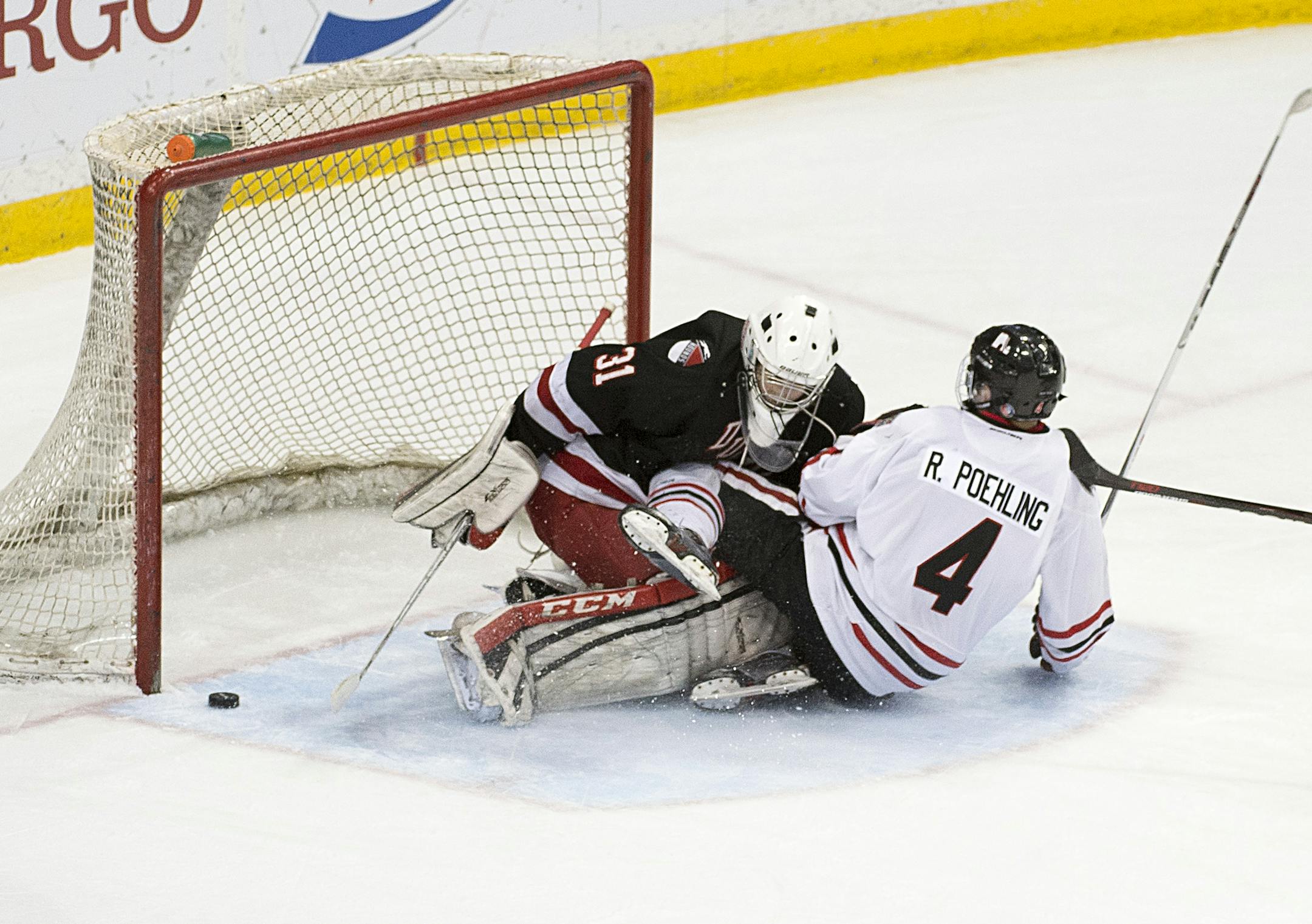 Lakeville North forward Ryan Poehling (4) slides skate first into Duluth East goalie Gunna Howg (31) while attacking the goal in the third period. ] (Aaron Lavinsky | StarTribune) Duluth East plays Lakeville North in the Class 2A boys' hockey championship game on Saturday, March 7, 2015 at Xcel Energy Center.