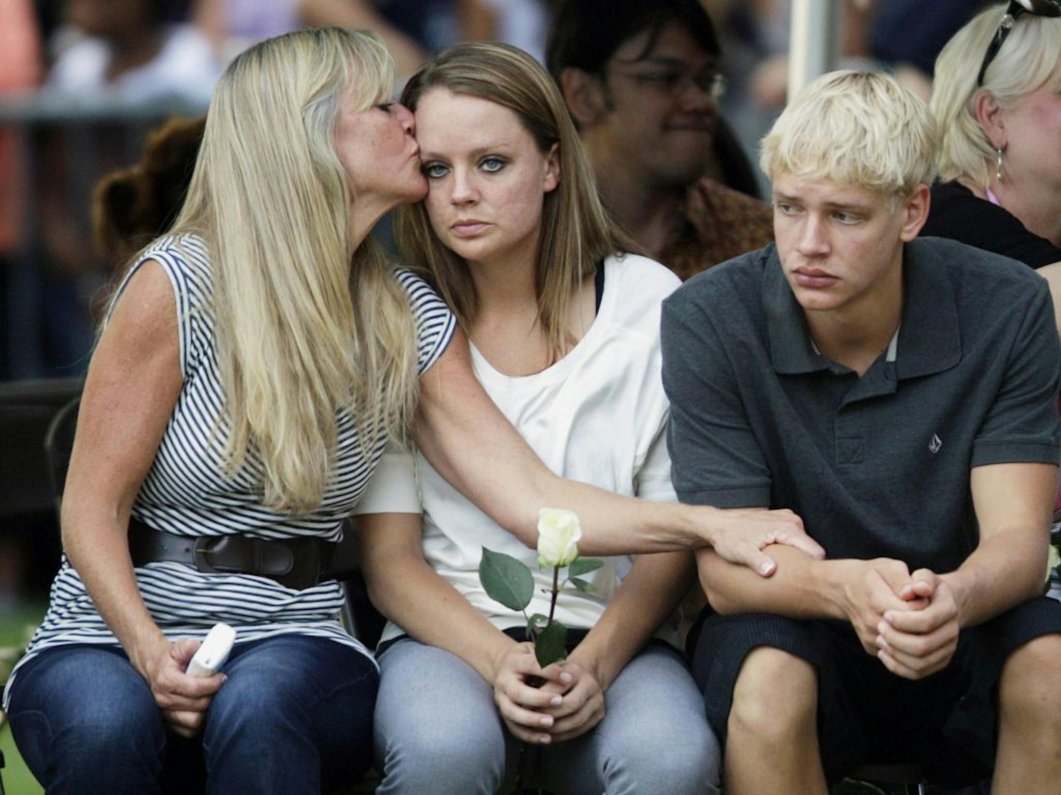 In this Sunday, July 22, 2012 file photo, family members of the victims of Friday's mass shooting at an Aurora, Colo., theater comfort each other during a prayer vigil in Aurora for the victims.