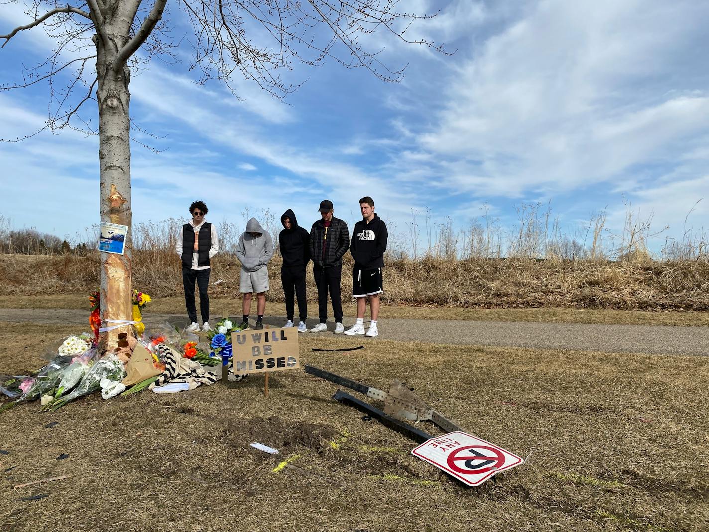 Friends of the victim involved in a fatal crash in Woodbury on Saturday night gathered at the scene of the crash Sunday afternoon where people brought flowers, candles and cards to a growing memorial. Four others were injured in the single-vehicle crash that remains under investigation. (Kim Hyatt/Star Tribune)