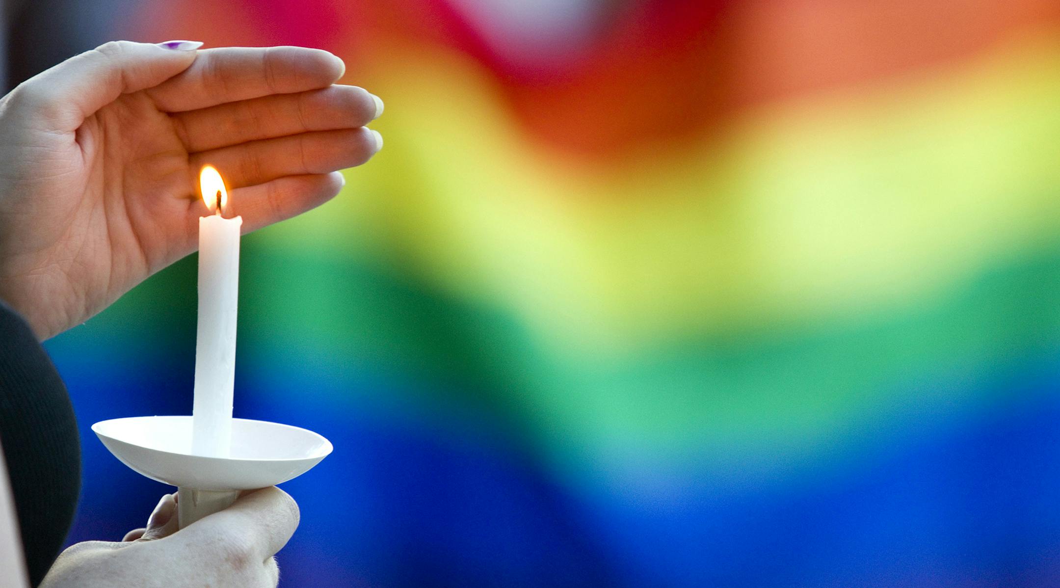A candle burns in front of a pride flag while community members gather for a vigil to honor the victims of the attack on a nightclub in Orlando, Fla. on Sunday, June 12, 2016, at Friendship Square in Moscow, Idaho. More than 150 people attended the vigil. (Geoff Crimmins/Moscow-Pullman Daily News via the AP) ORG XMIT: MIN2016061511565526