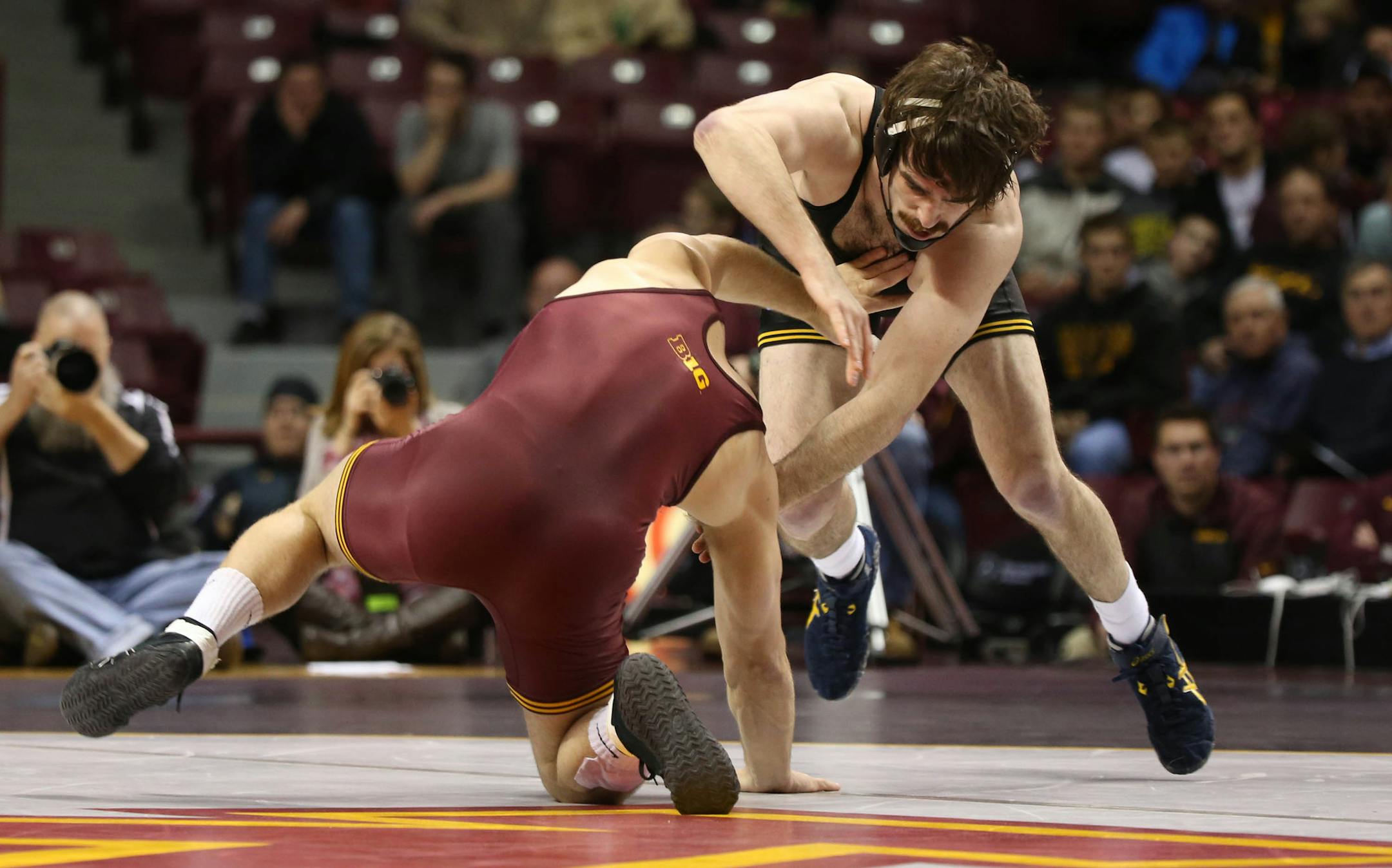 Iowa's Mike Evans avoided being taken down by Gopher Logan Storley in the 174 weight class.