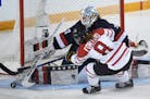 Canada's Laura Fortino tries to get the puck past United States goalie Alex Rigsby during the first period of the women's world hockey championships M