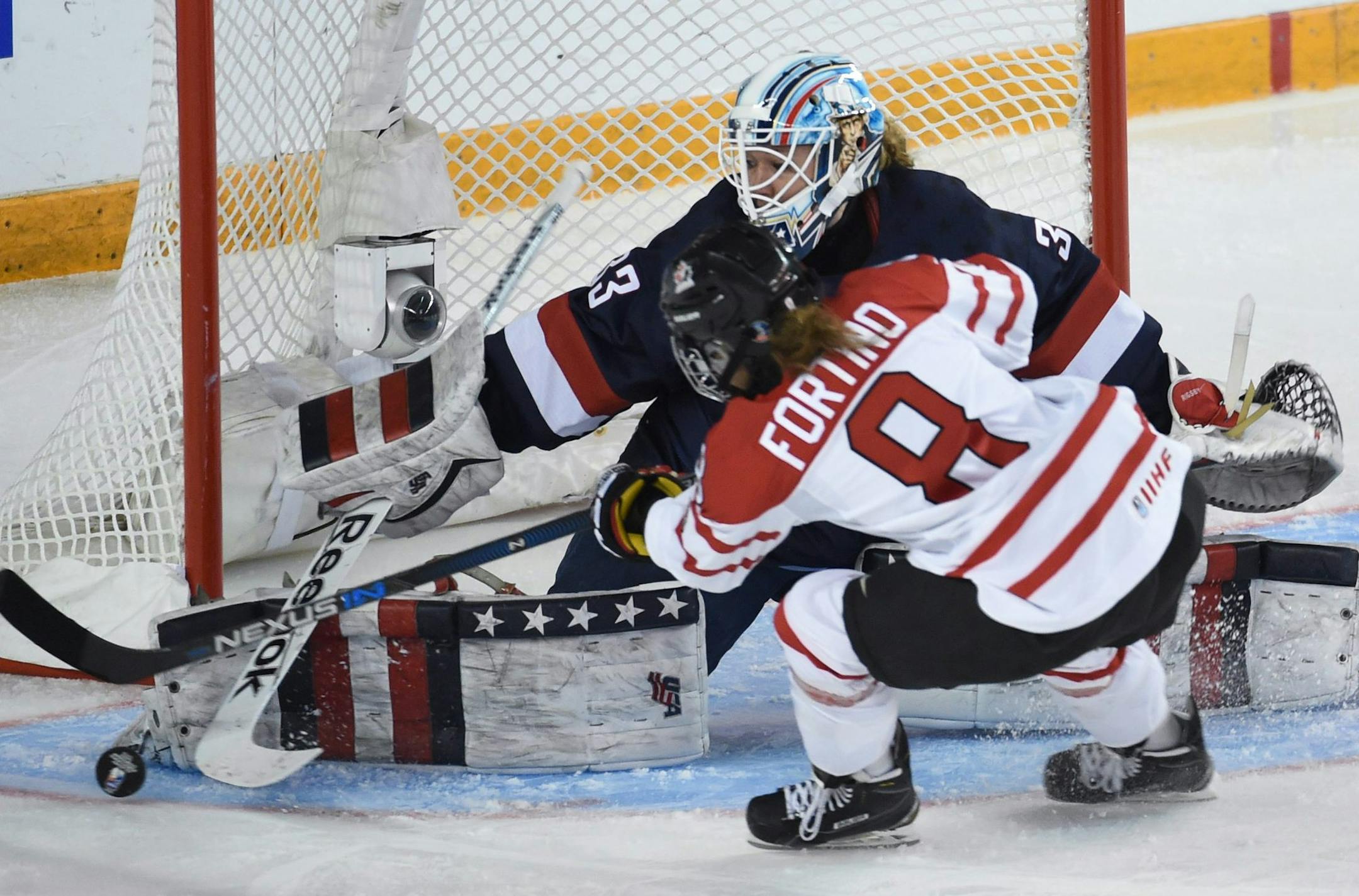 Canada's Laura Fortino tries to get the puck past United States goalie Alex Rigsby during the first period of the women's world hockey championships Monday, April 4, 2016, in Kamloops, British Columbia. (Ryan Remiorz/The Canadian Press via AP) MANDATORY CREDIT