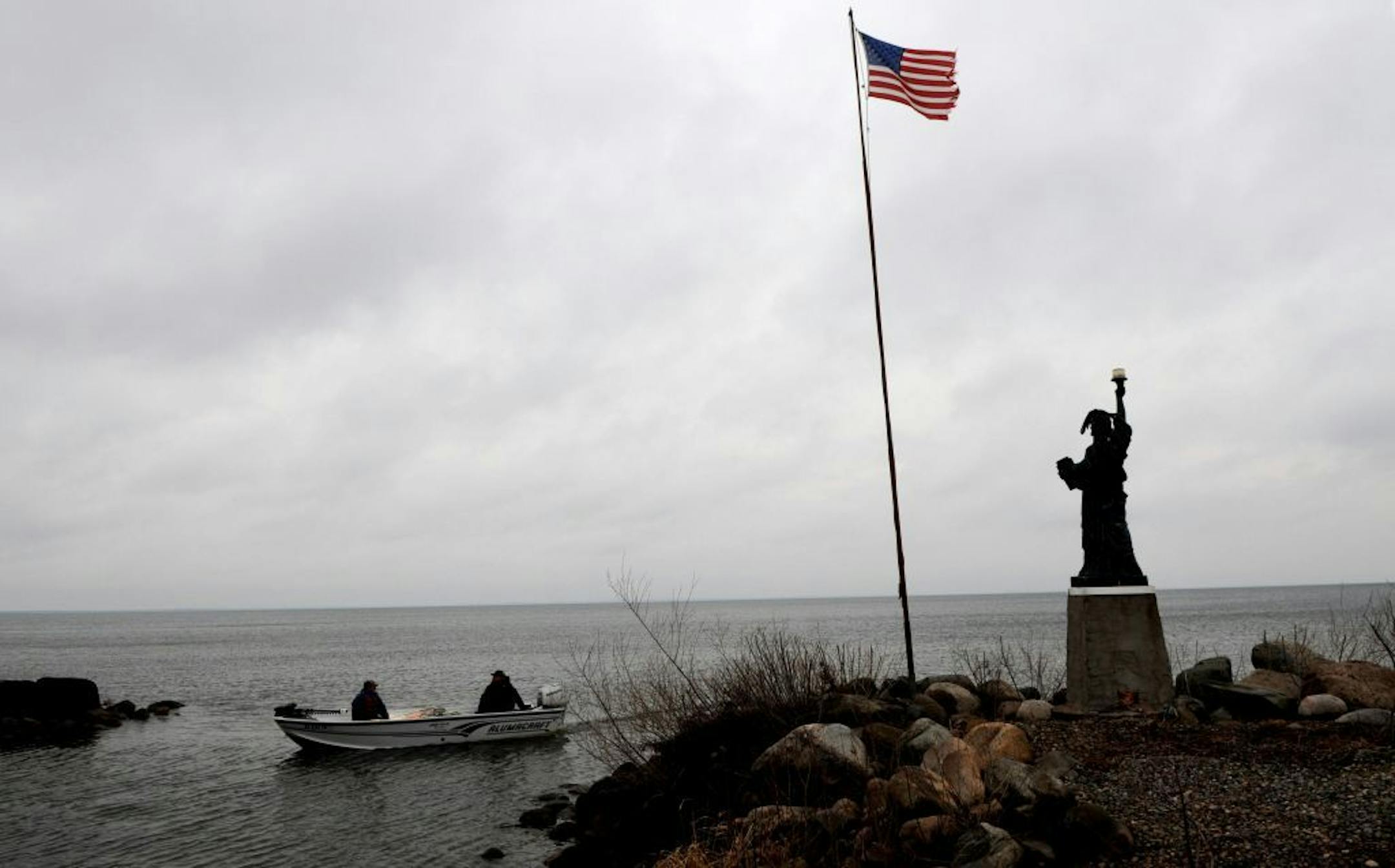 Isle, Mn. Tuesday 4/13/10 The Mille Lacs band of Chippewa have started the annual Spring netting of walleye on Lake Mille Lacs. Fishermen return to Liberty Beach public access in Isle, Mn. with a load of netted fish and were greeted by a replica statue of liberty and the American flag blowing in a stiff breeze.