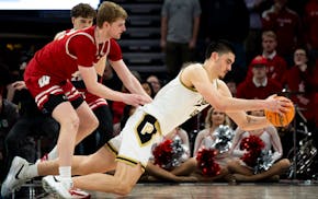 Purdue center Zach Edey falls to the floor as he's defended by Wisconsin's Steven Crowl on Saturday.