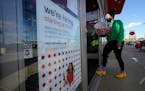 A passerby walks past a hiring sign while entering a Target store in Westwood, Mass., in September 2020.