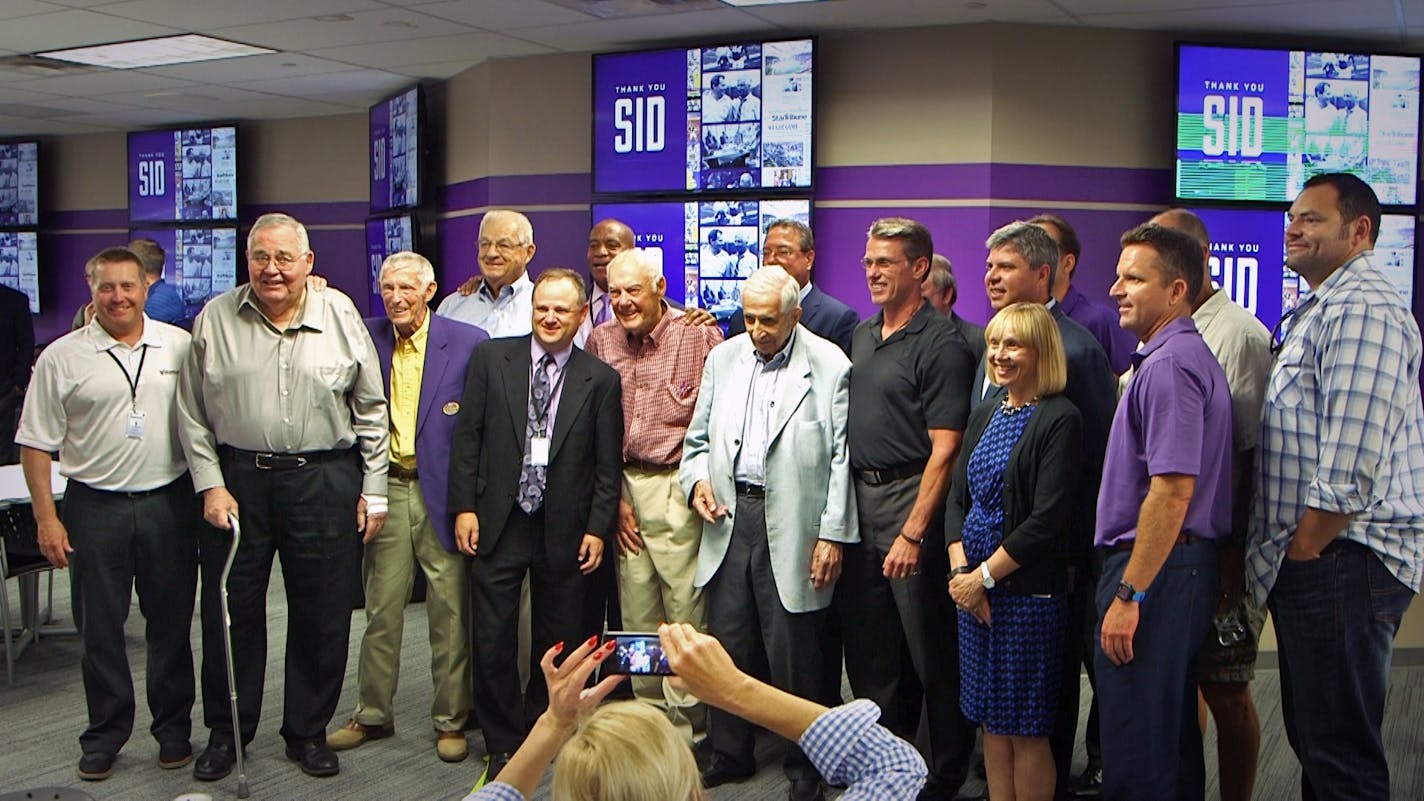 Attendees of the Sid Hartman gate commemoration at U.S. Bank Stadium pose for a photo with the namesake.