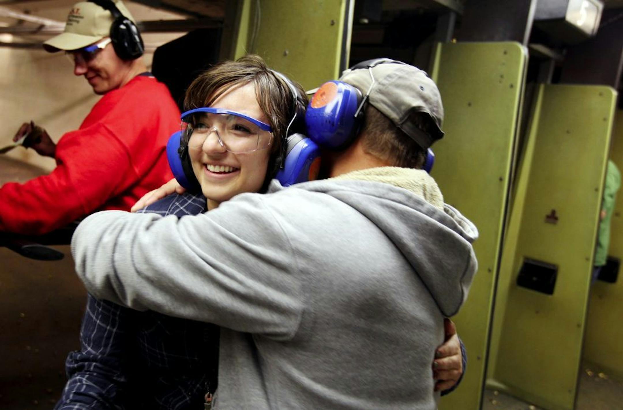 Liz Davey, 19, of Winona hugs Tim Magdik, her mother's boyfriend, of Blaine after she shot a gun for the first time at Burnsville Rifle and Pistol Range October 15, 2011. Davey completed a Personal Firearms Safety Training course and will go on an inaugural deer hunt with Magdik's family this year. Magdik joined Davey at the gun range and is honored that she's seeking his wisdom. "If she gets a deer," says Magdik, "I'll be passing on my secret jerky recipe that's been in our family since the 192