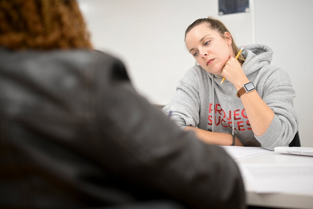 Project Success facilitator Clara Kennedy watches as one of her students writes a response to a prompt on insurance during a money management class Tuesday in Minneapolis.