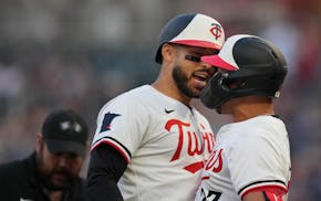 Shortstop Carlos Correa joins the Twins' Royce Lewis in celebrating Correa's home run Tuesday night.