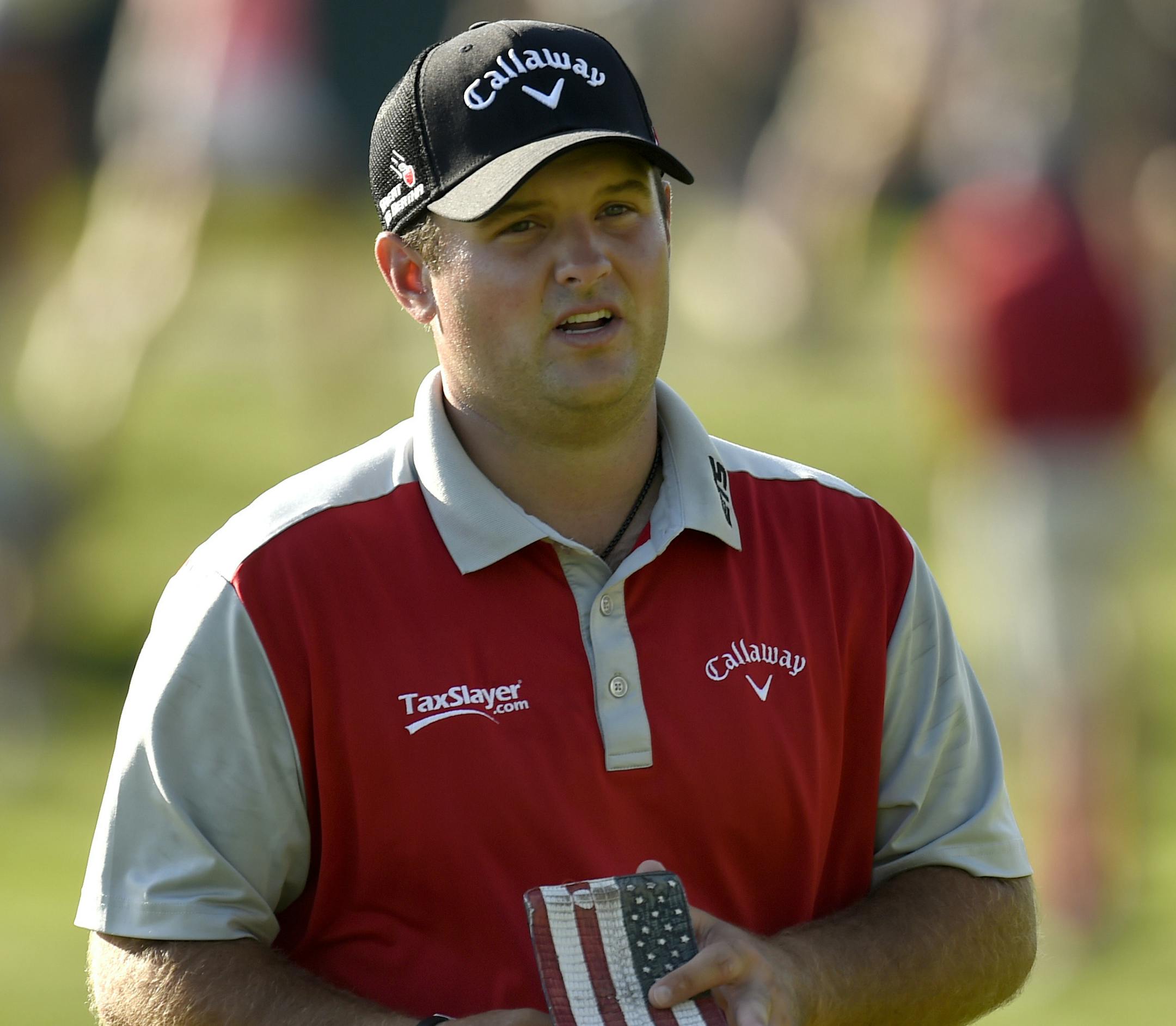 Patrick Reed holds his "Stars and Stripes" score book while walking off the 17th green during the first round of the Travelers Championship golf tournament, Thursday, Aug. 4, 2016, in Cromwell, Conn. (John Woike/Hartford Courant via AP)