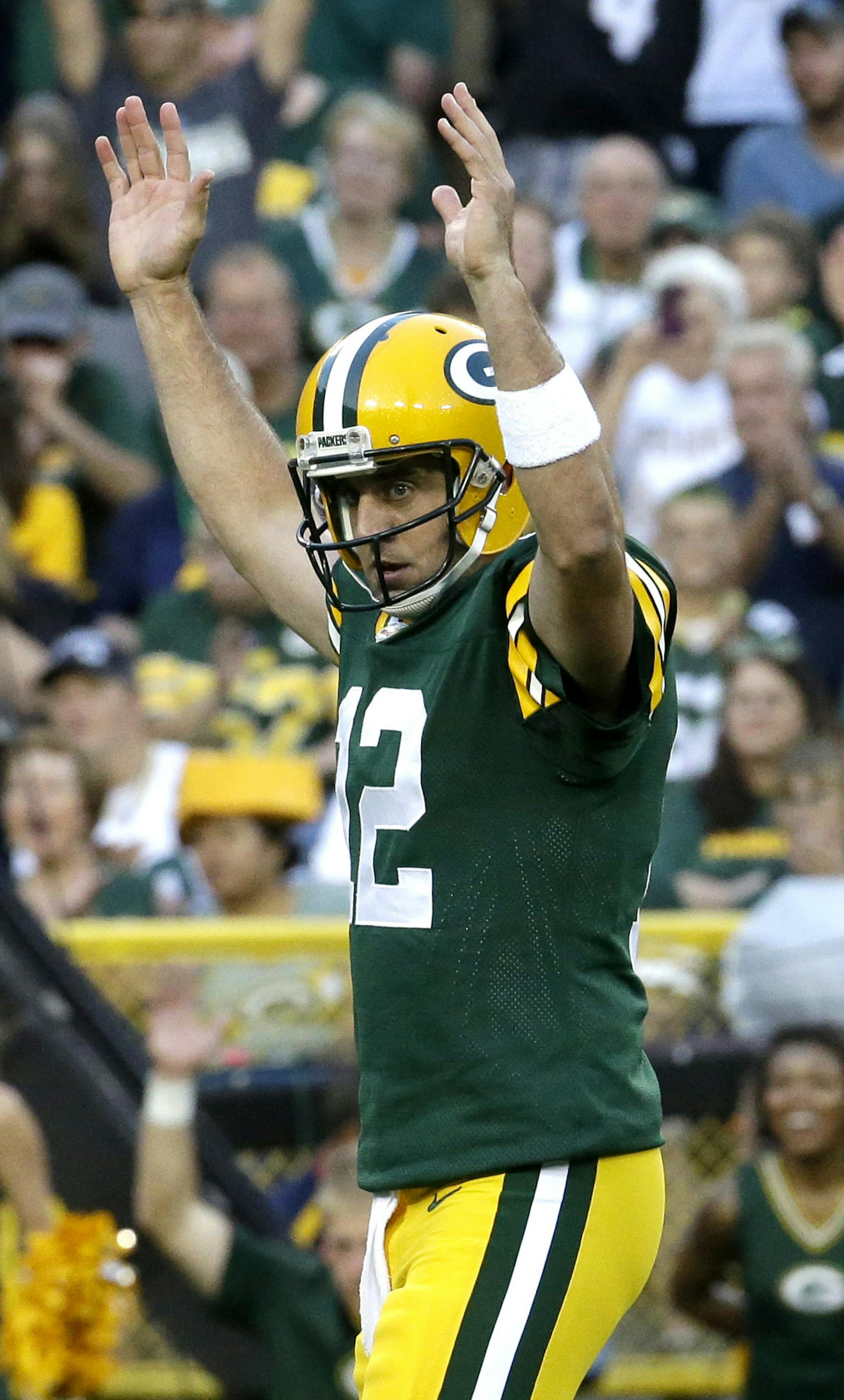 Green Bay Packers quarterback Aaron Rodgers (12) signals a touchdown after the Packers scored against the Oakland Raiders during the first quarter of an NFL preseason football game Friday, Aug. 22, 2014, in Green Bay, Wis. (AP Photo/Morry Gash) ORG XMIT: WIMG106