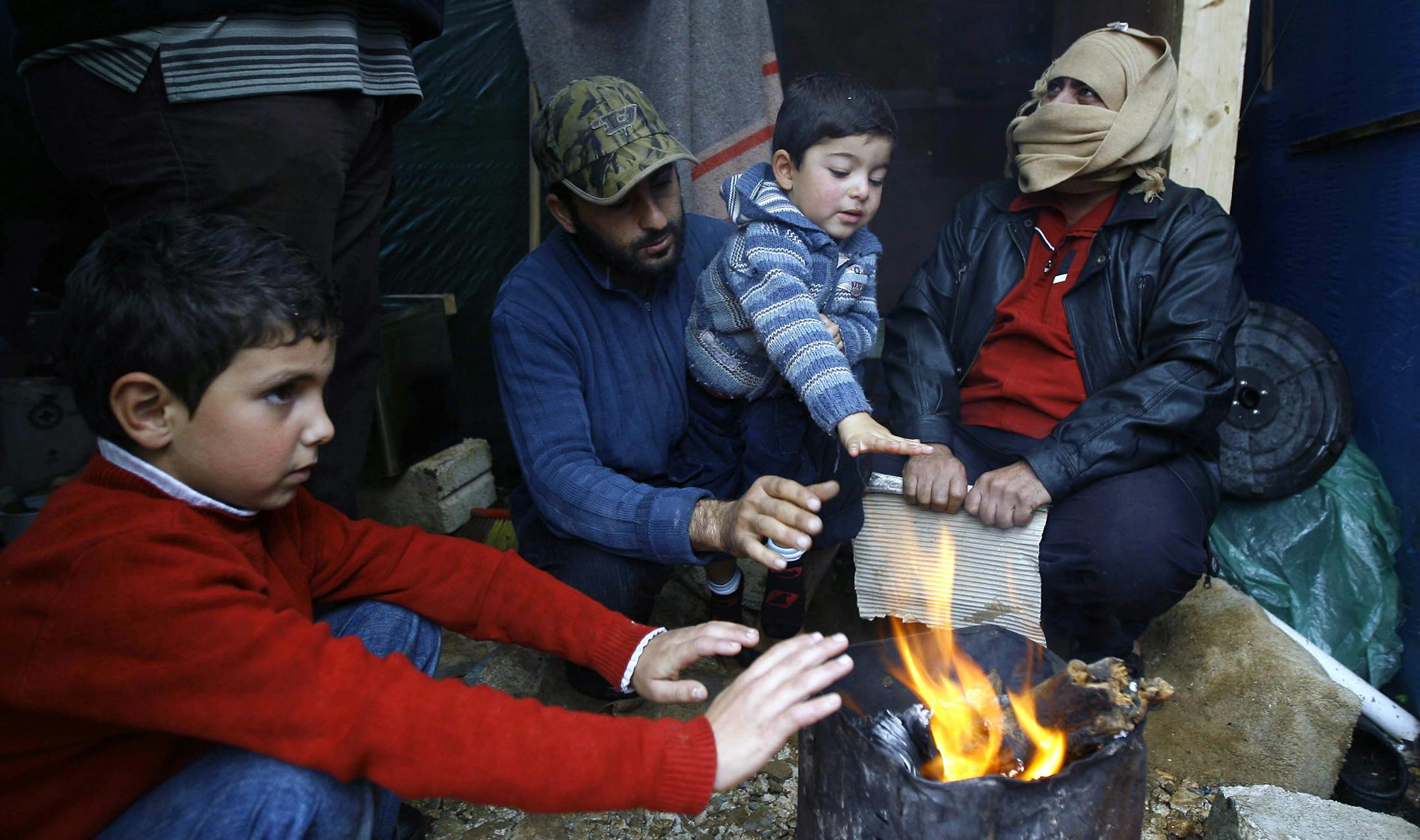 Syrian refugees warm themselves around a bonfire near their tent as a heavy snowstorm batters the region, in a camp for Syrians who fled their countryís civil war, in the Chouf mountain town of Ketermaya, Lebanon, Wednesday, Dec. 11, 2013. The United Nations refugee agency says it is "extremely concerned" for hundreds of thousands of Syrian refugees scattered across the region amid a snowstorm with high winds and torrential rains. (AP Photo/Mohammed Zaatari)
