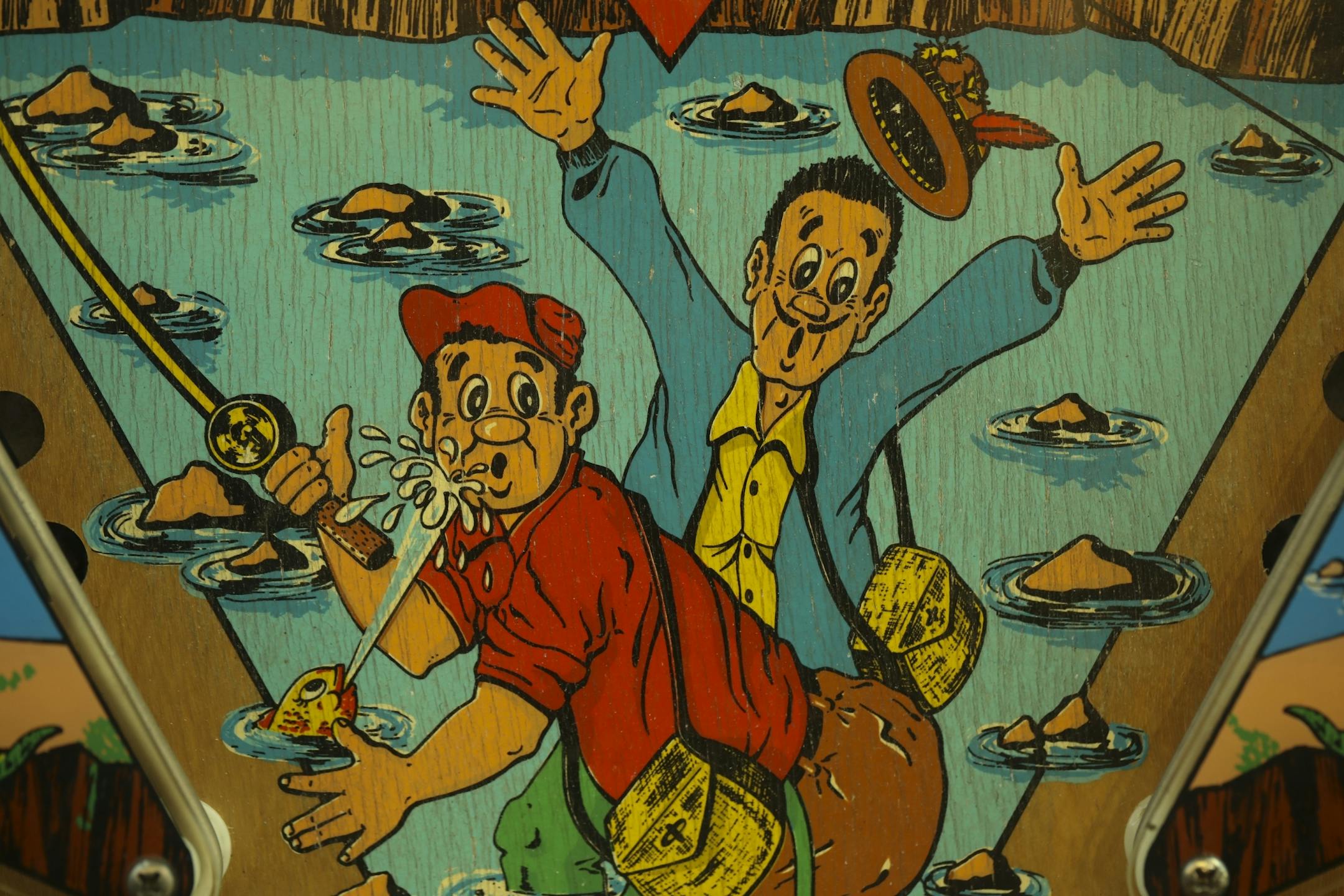 Detail of the artwork on a Bally machine called Nip-it, with a fishing theme.