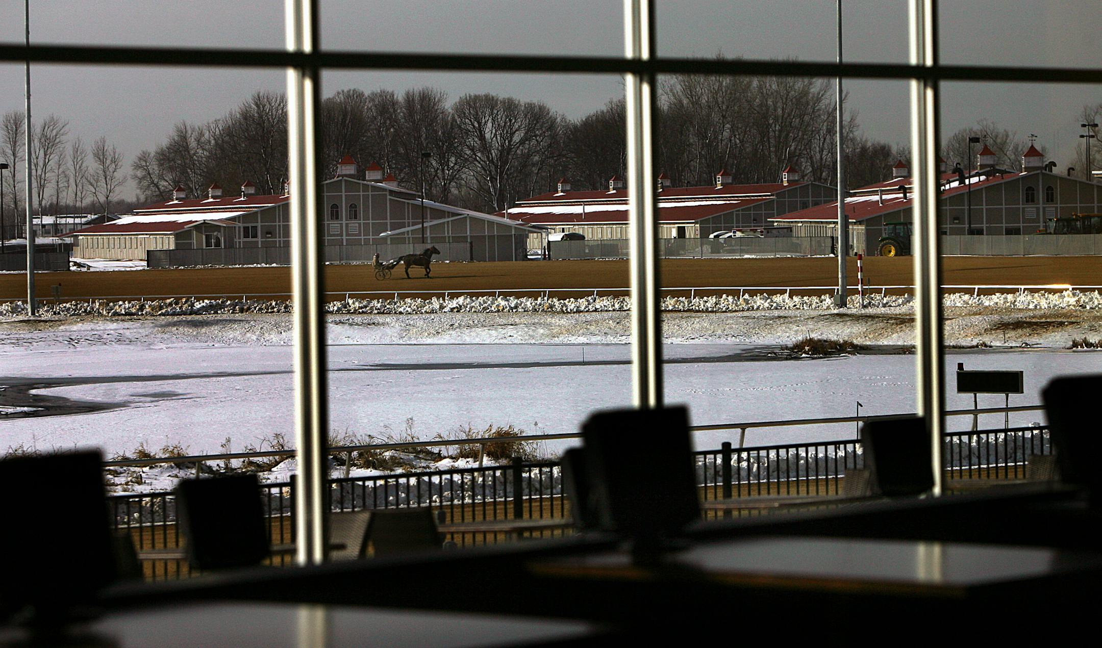 Riders can be seen through the large windows in the main building at the new Running Aces Harness Track in Forest Lake as riders put their horses through their paces in preparation for the upcoming opening day.
