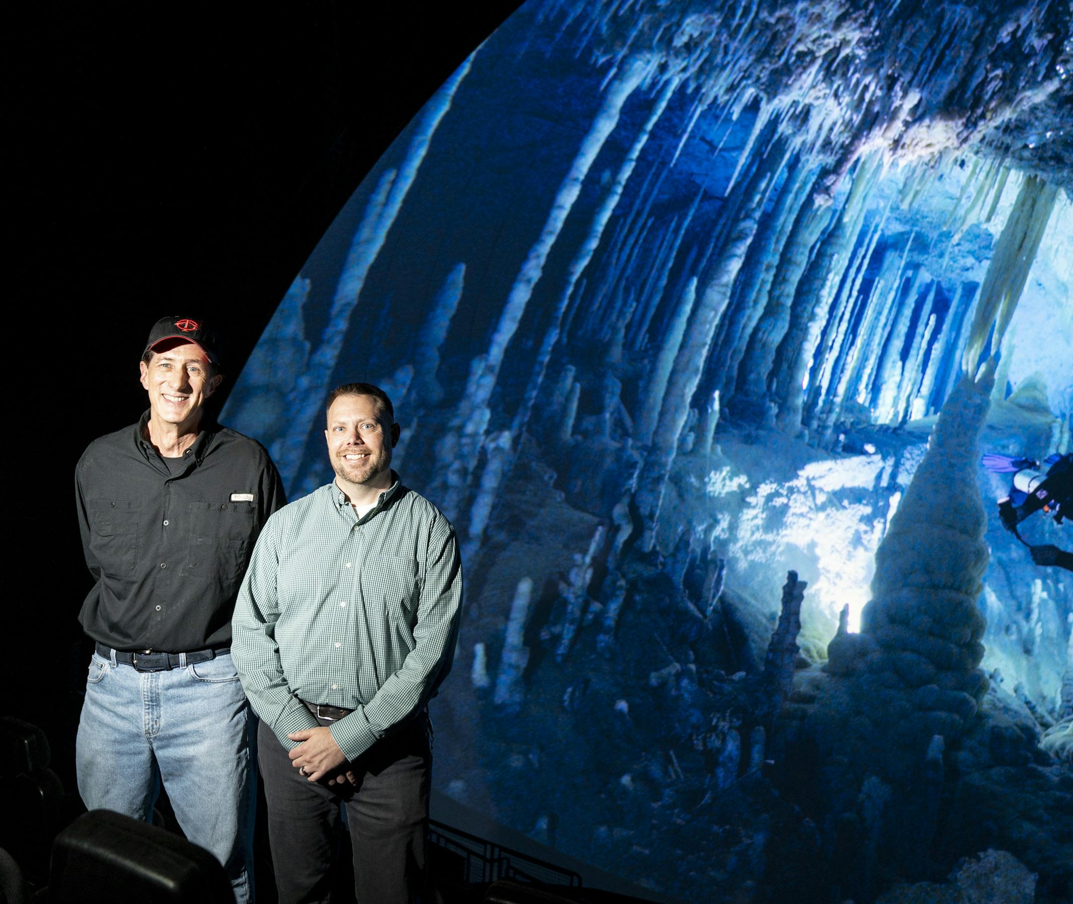 Founding director of the Omnitheater Mike Day and Omnitheater technical director Chris Demko posed for a photo in from of the new digital Omnitheater with the production Ancient Caves on the screen at the Science Museum of Minnesota in St. Paul, Minn., on Monday, October 7, 2019. We we able to pause the film to get this shot, something the previous film projector could not do. ] RENEE JONES SCHNEIDER &#xa5; renee.jones@startribune.com