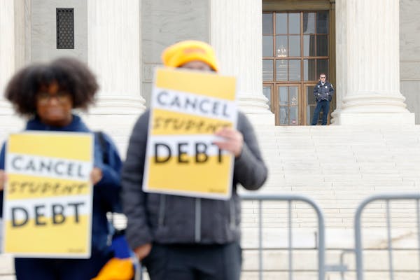 A police officer watches as student loan borrowers and advocates gather for the People’s Rally to Cancel Student Debt during Supreme Court hearings 