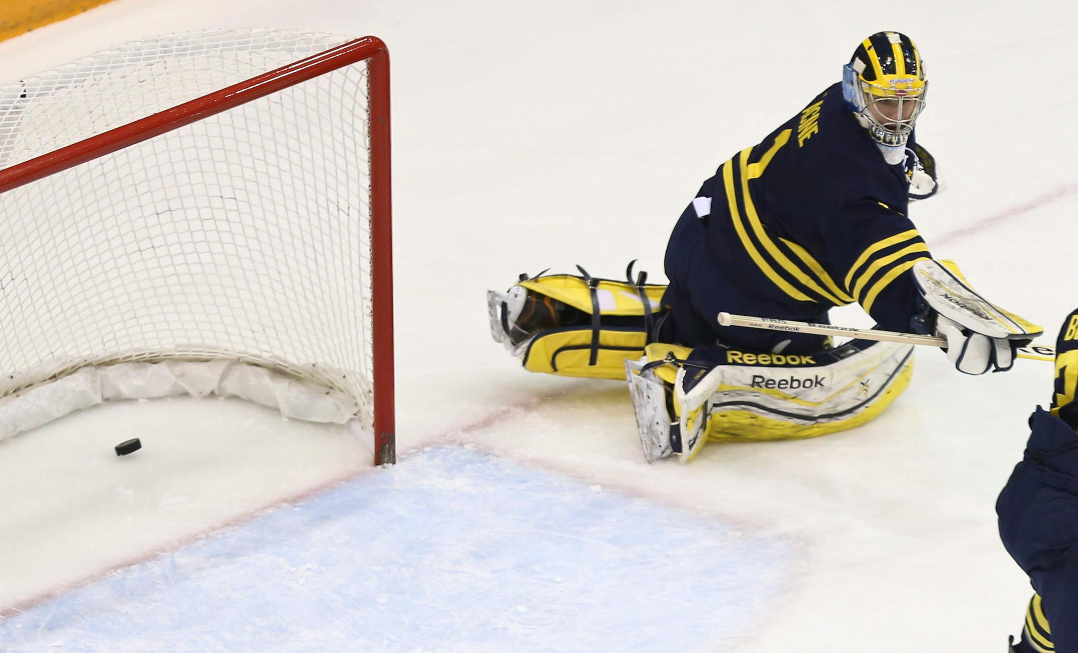 Michigan goalie Steve Racine looked back as Minnesota's Justin Kloos scored the first point during the first period.