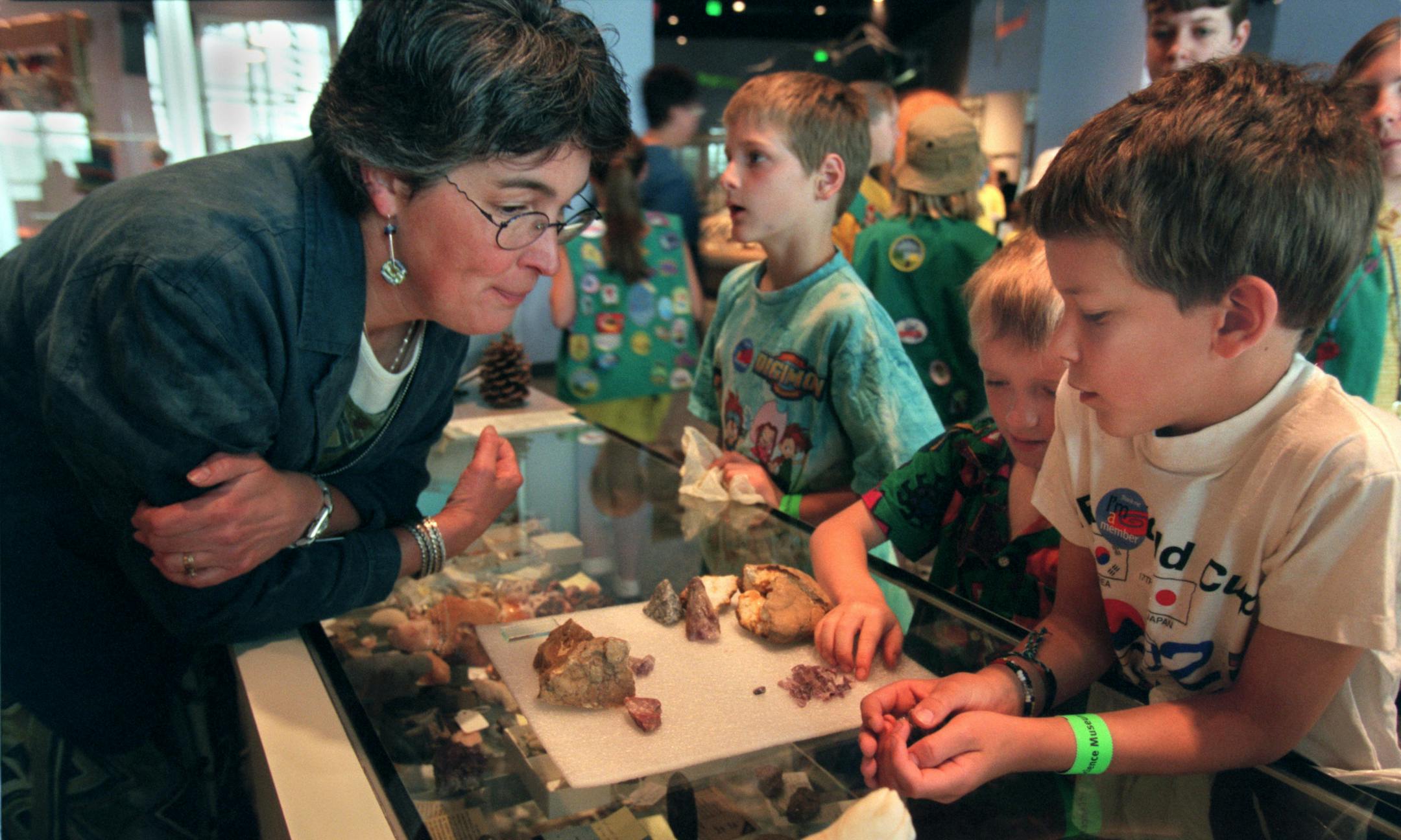 The CollectorsÌ Corner at the Science Museum of Minnesota gives kids a chance to bring in nature items and trade them for other items. -- St. Paul, Mn., Tues., June 13, 2000--(Left ) Kate Hintz, manager of the CollectorsÌ Corner at the Science Museum of Minnesota, looks over the rocks eight-year-old Rio Hart of Minneapolis brought in to eventually trade for a muskrat skull. (Hart is at far right. Beside Hart is six-year-old Keenan Lidral-Porter of Minneapolis. In the center of the phot
