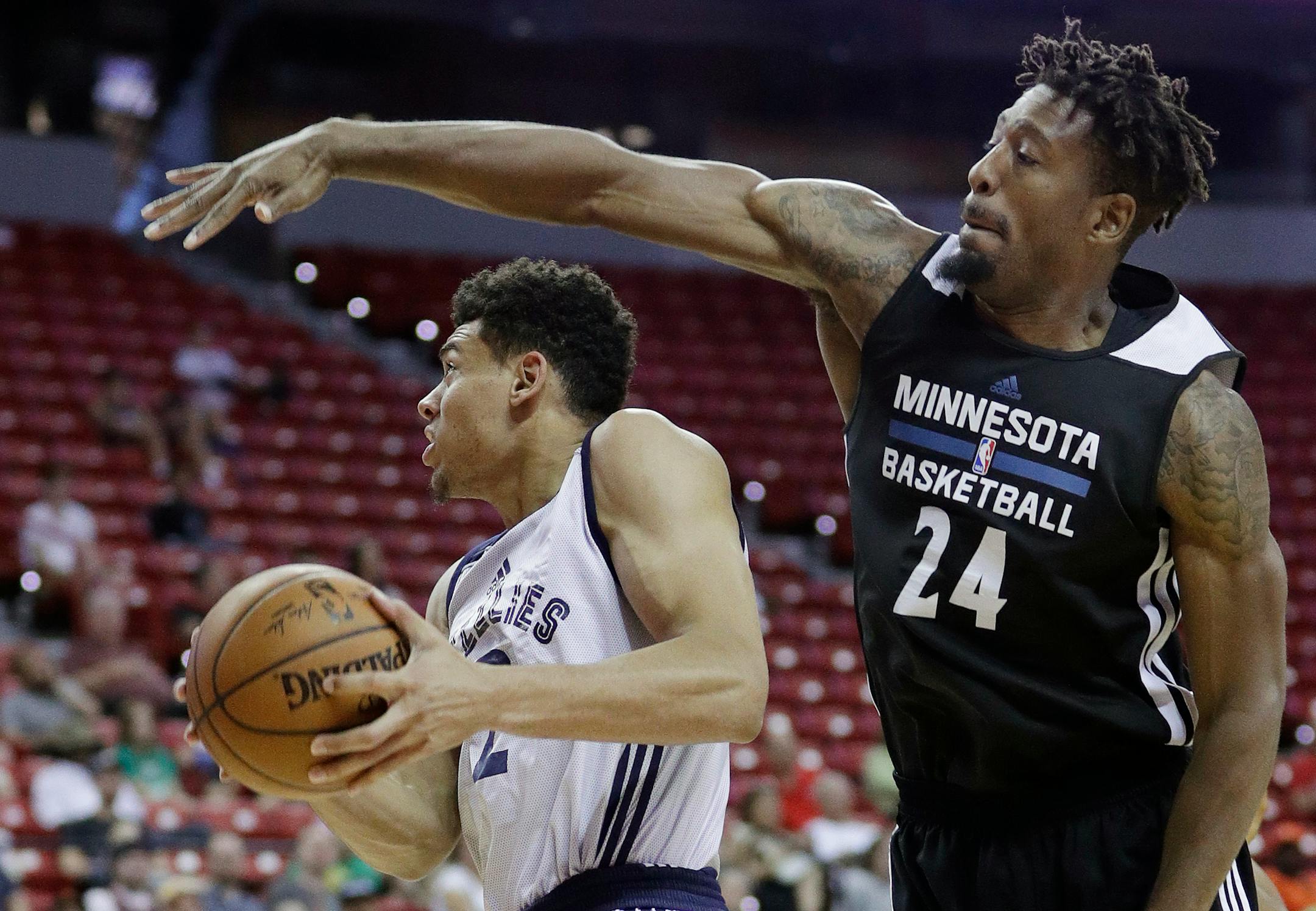 Minnesota Timberwolves' Jarrid Famous fouls Memphis Grizzlies' Wade Baldwin IV during the first half of an NBA summer league basketball game Thursday, July 14, 2016, in Las Vegas. (AP Photo/John Locher)