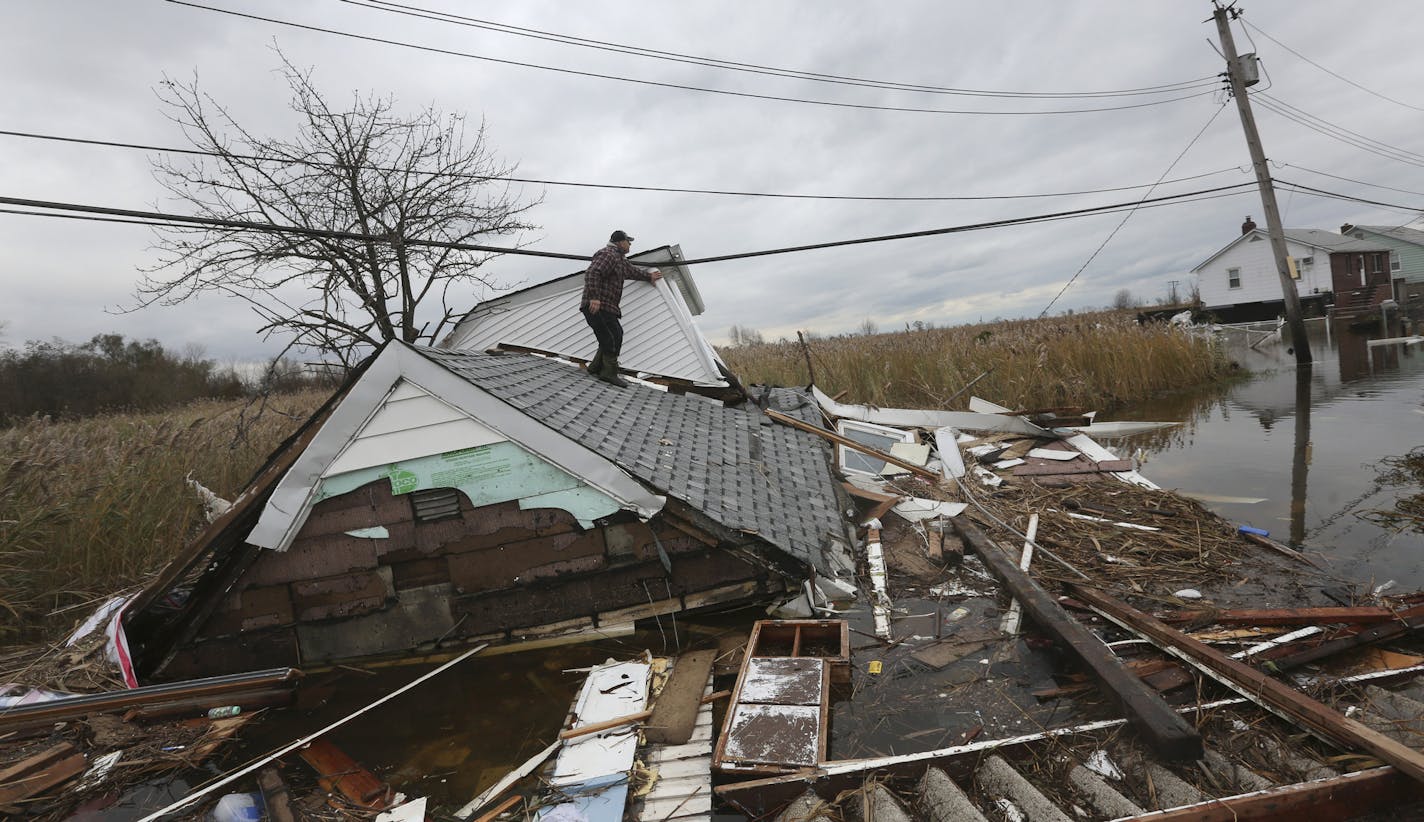 FILE -- Claudio Finco surveys the damage of his neighbor's after Hurricane Sandy, in the Staten Island borough of New York, Nov. 1, 2012. Those who declare tax losses from the hurricane will run into limits on what they can claim, as well as the question of what constitutes fair value. (Michael Appleton/The New York Times) ORG XMIT: XNYT83