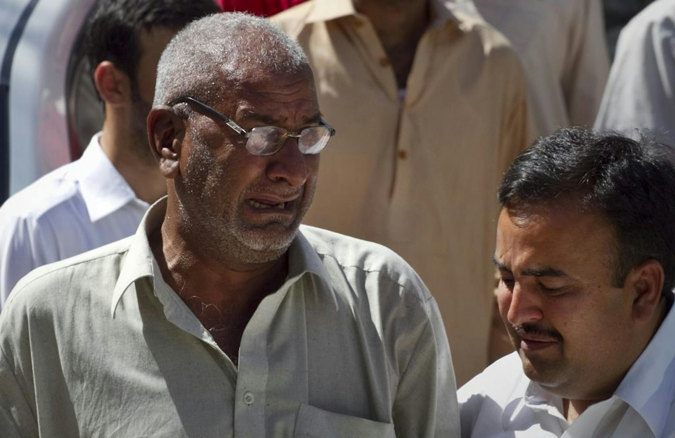 A man comforts the brother of Pakistani prosecutor Chaudhry Zulfikar who was assassinated hours earlier, outside his residence in Islamabad, Pakistan, Friday, May 3, 2013. Gunmen killed Pakistan's lead prosecutor investigating the assassination of former prime minister Benazir Bhutto as he drove to court in the capital on Friday, throwing the case that also involves former ruler Pervez Musharraf into disarray.