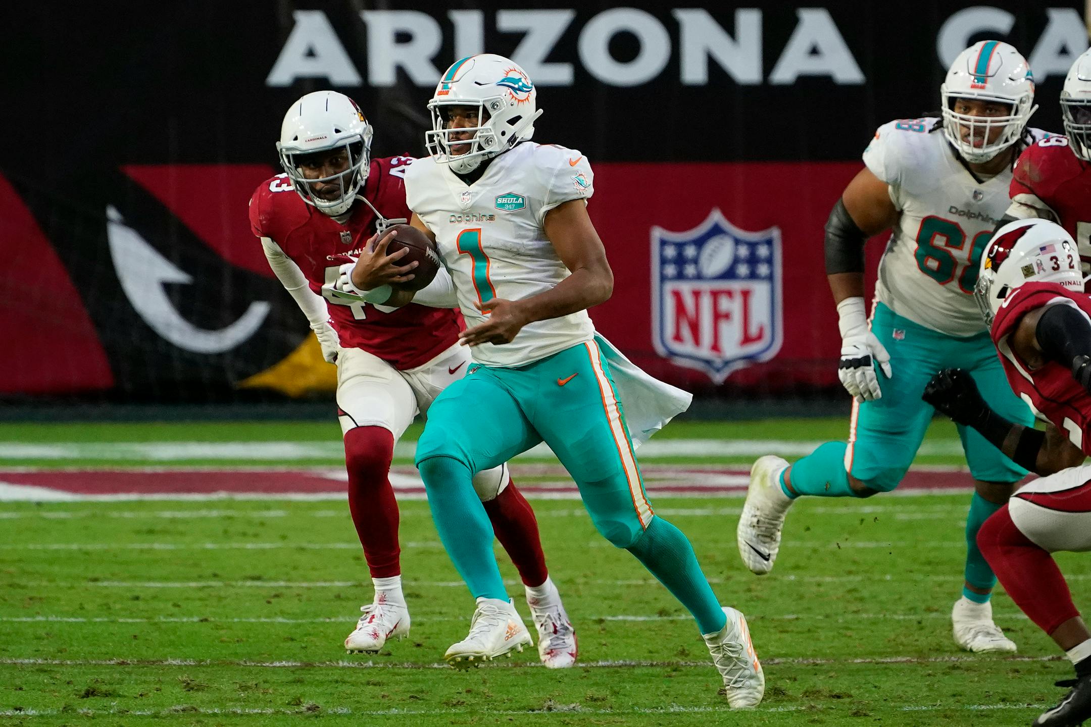 Miami Dolphins quarterback Tua Tagovailoa (1) runs as Arizona Cardinals outside linebacker Haason Reddick (43) pursues