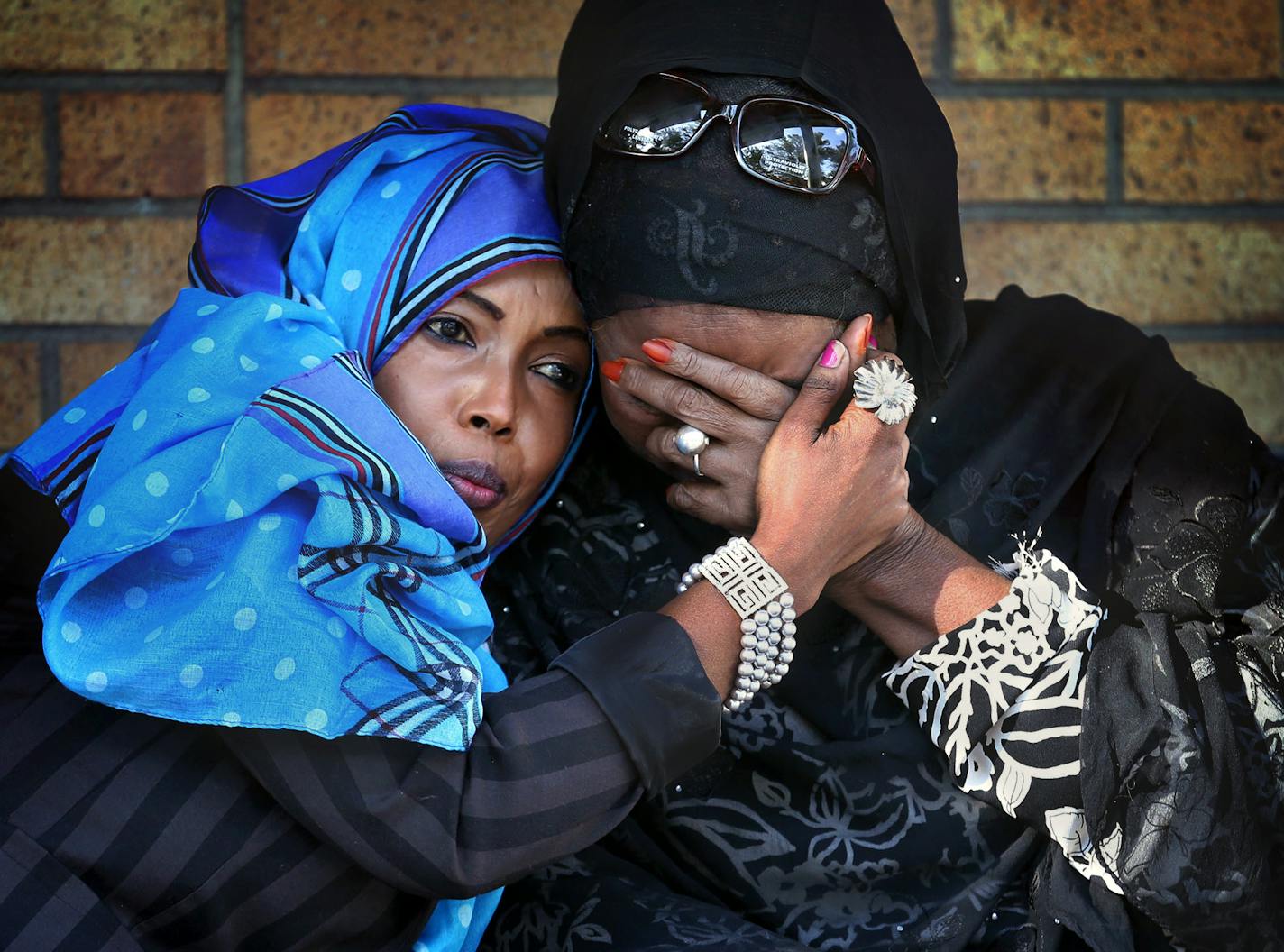 Adar Kahin comforted her fellow singer Hibo Nuura, long time friend, during a vigil for the singer and activist Saado Ali Warsam. The Nuura ans Warsam were members of a musical troupe called Waaberi. Saado Ali Warsame was killed when gunmen attacked her car in Mogadishu. The singer and political activist will be mourned at and around Brian Coyle Center in Minneapolis, Min. Thursday, July 24, 2014.