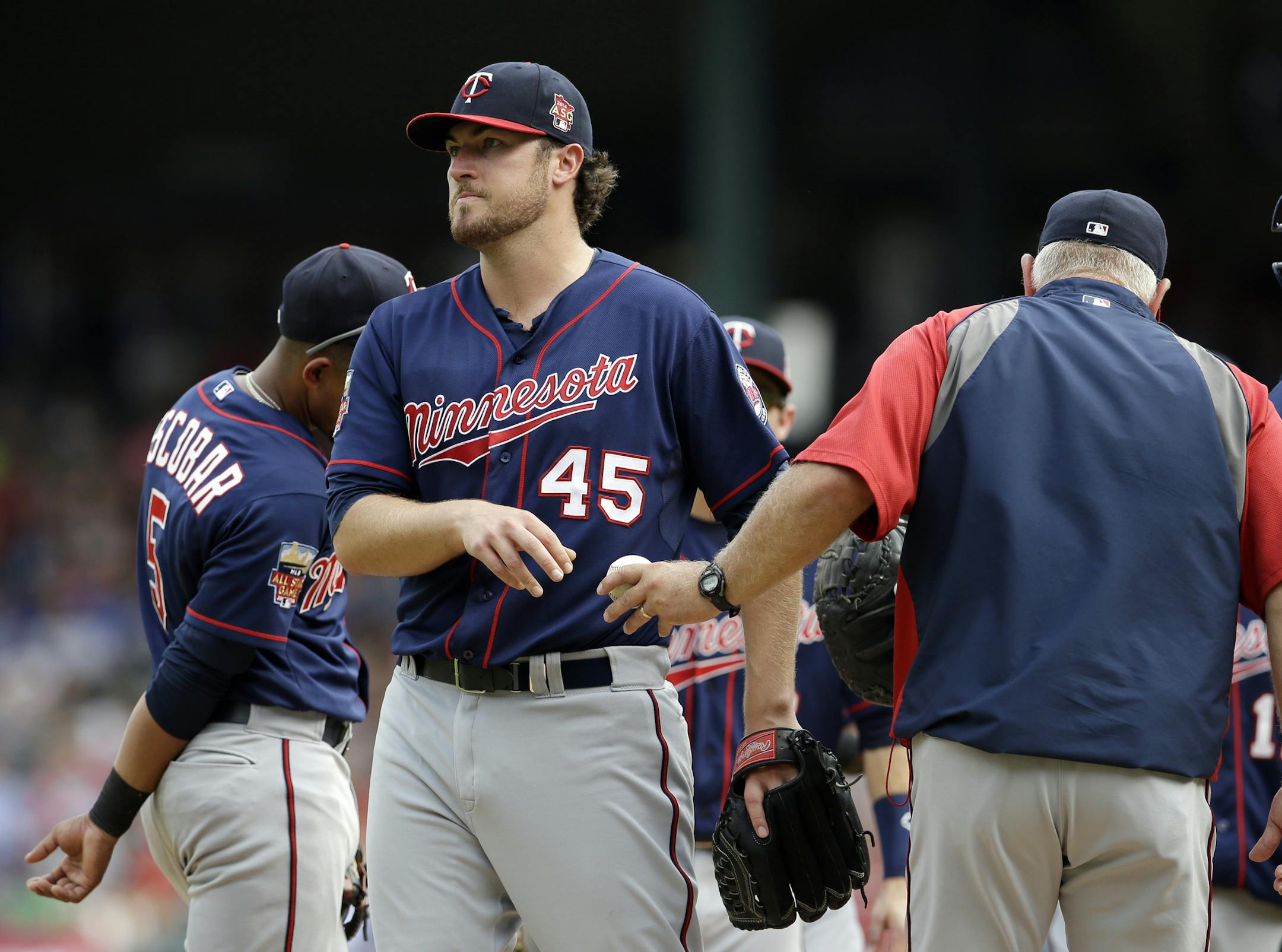 Minnesota Twins starting pitcher Phil Hughes hands the ball over to manager Ron Gardenhire, right, as he walks off the mound in the eighth inning of a baseball game against the Texas Rangers, Saturday, June 28, 2014, in Arlington, Texas. The Rangers won 5-0. (AP Photo/Tony Gutierrez)