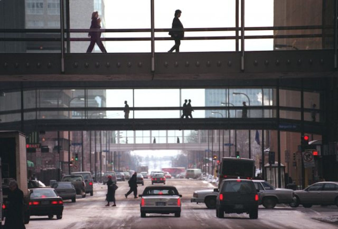 The Minneapolis street scene is elevated one floor up as downtown business people navigate the skyway system. This view looking east on S. 8th St. from the Nicollet Mall.