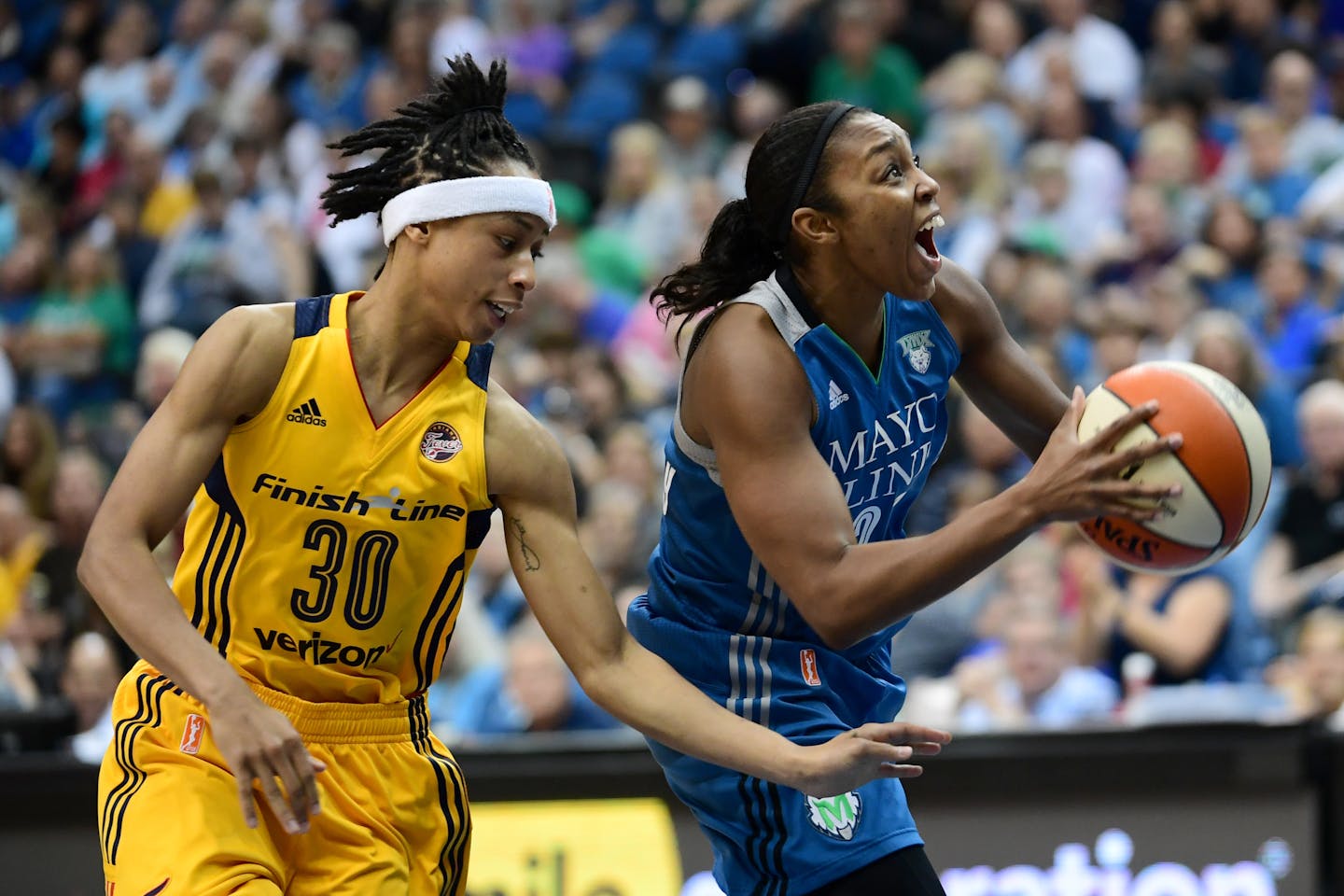 Minnesota Lynx guard Renee Montgomery (21) was able to power through a foul by Indiana Fever guard Brene Moseley (30) to score a layup before hitting a free throw.