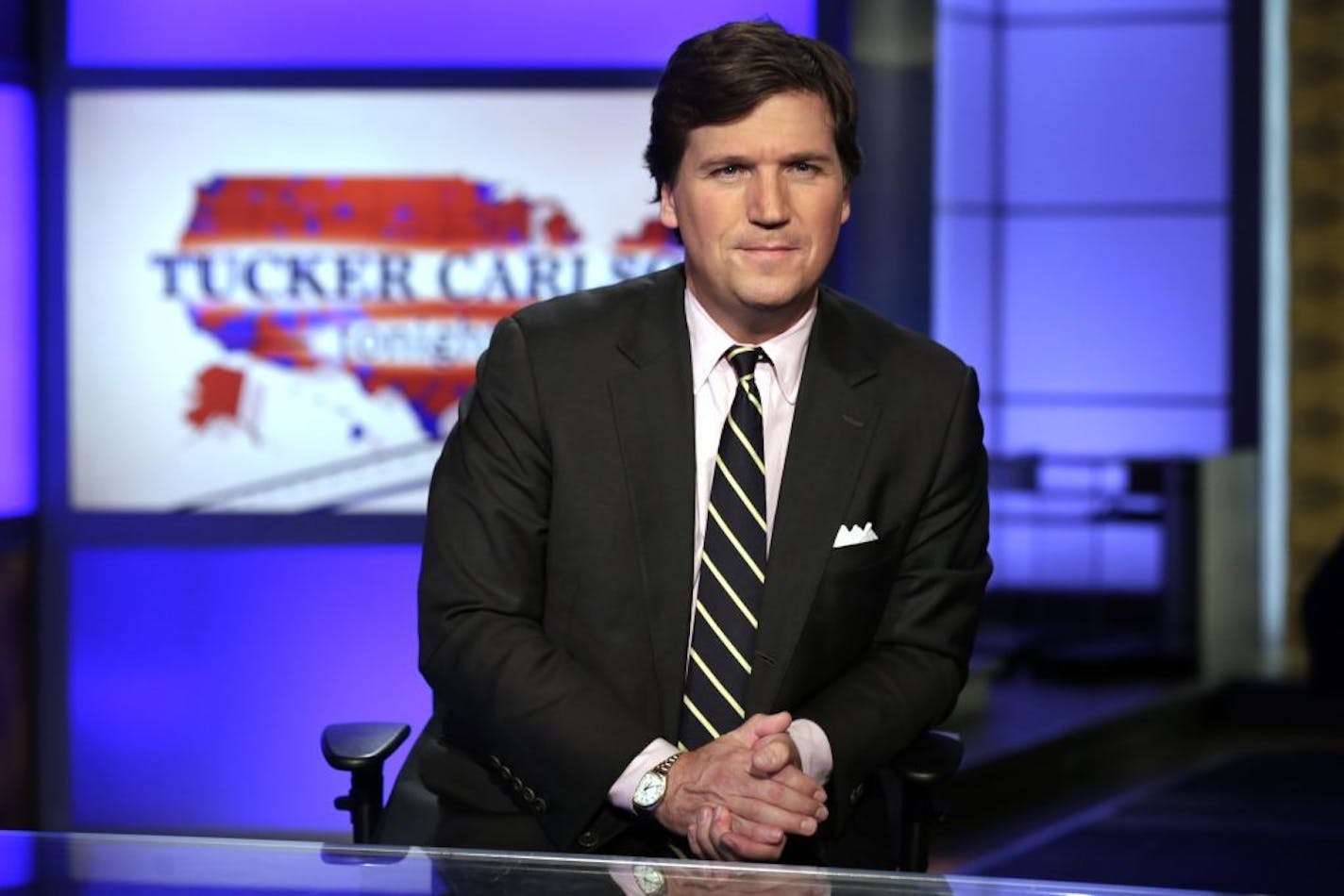 FILE - In this March 2, 2017, file photo, Tucker Carlson, host of "Tucker Carlson Tonight," poses for photos in a Fox News Channel studio in New York. Washington police are investigating a protest outside the home of Carlson as a possible hate crime. According to a police report, a group of demonstrators gathered outside Carlson's Northwest Washington home Wednesday night, Nov. 7, 2018. A video posted on social media but later removed shows people standing outside a darkened home chanting "Tucke