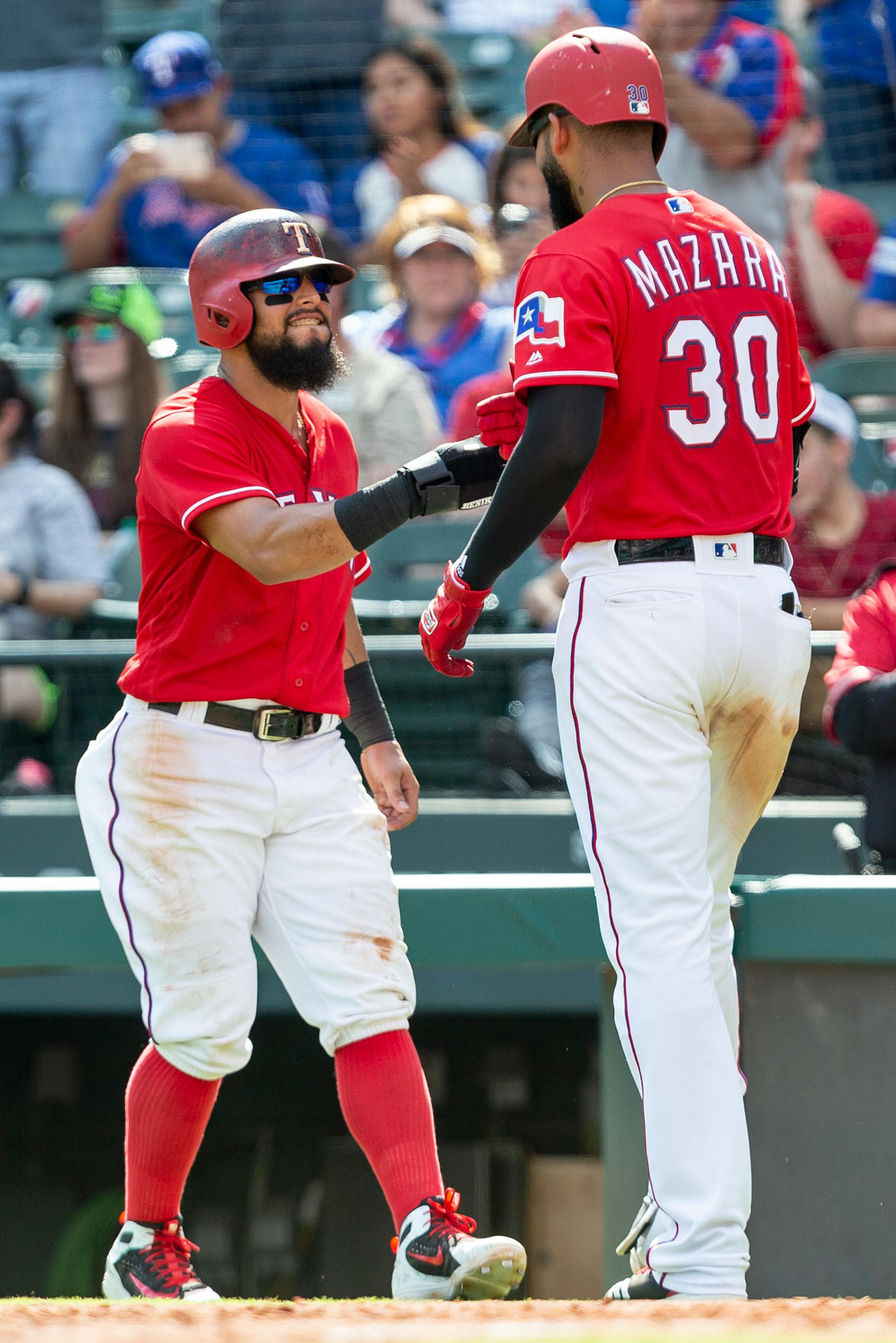 Texas Rangers' Nomar Mazara (30) is congratulated by teammate Rougned Odor after hitting a home run during the sixth inning of a baseball game against the Minnesota Twins, Sunday, Sept. 2, 2018, in Arlington, Texas. (AP Photo/Sam Hodde)