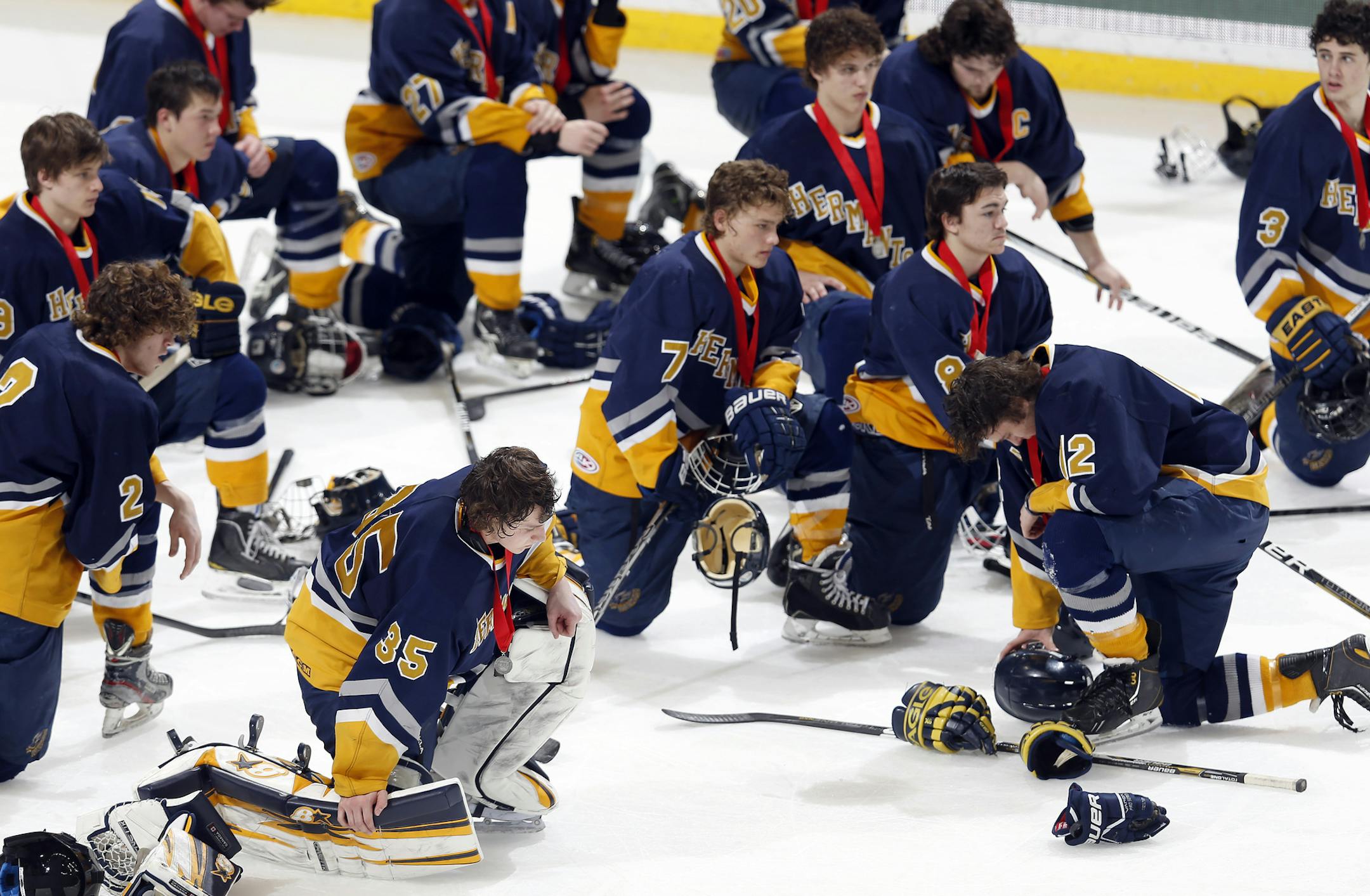 Hermantown players knelt on the ice after receiving their second place medals. St. Thomas Academy beat Hermantown by a final score 5-4. ] CARLOS GONZALEZ cgonzalez@startribune.com - March 9, 2013, St. Paul, Minn., Xcel Energy Center, Minnesota High School Boys State Hockey, 1A Finals, St. Thomas Academy vs. Hermantown