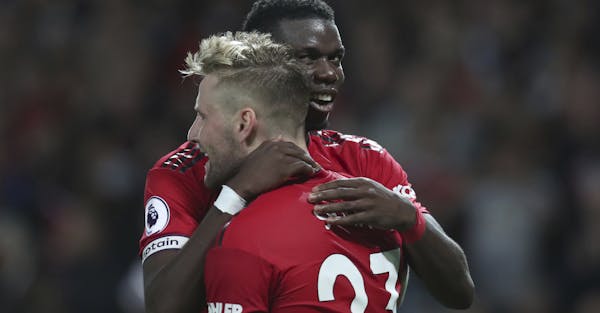 Manchester United's Luke Shaw, front, is hugged and congratulated by Manchester United's Paul Pogba, after he scored his sides second goal of the game