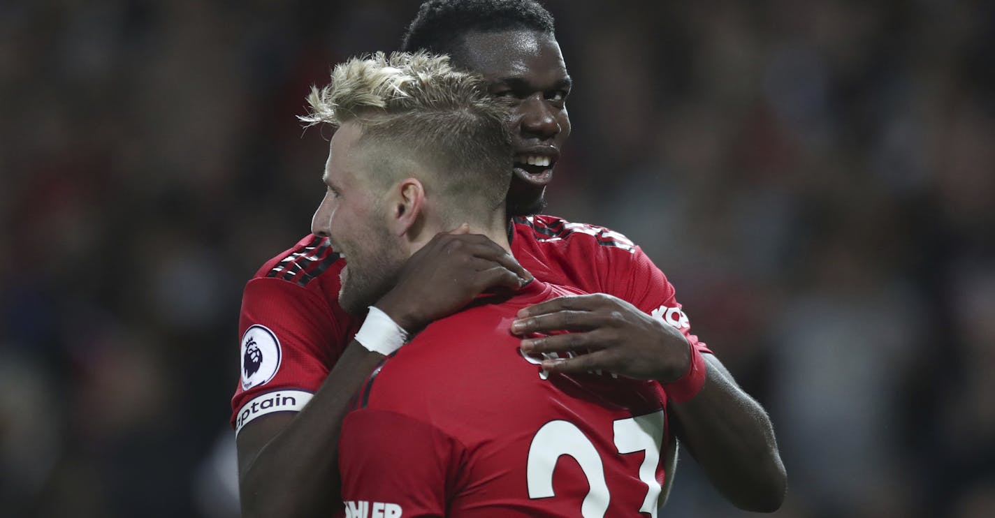 Manchester United's Luke Shaw, front, is hugged and congratulated by Manchester United's Paul Pogba, after he scored his sides second goal of the game during the English Premier League soccer match between Manchester United and Leicester City at Old Trafford, in Manchester, England, Friday, Aug. 10, 2018. (AP Photo/Jon Super)