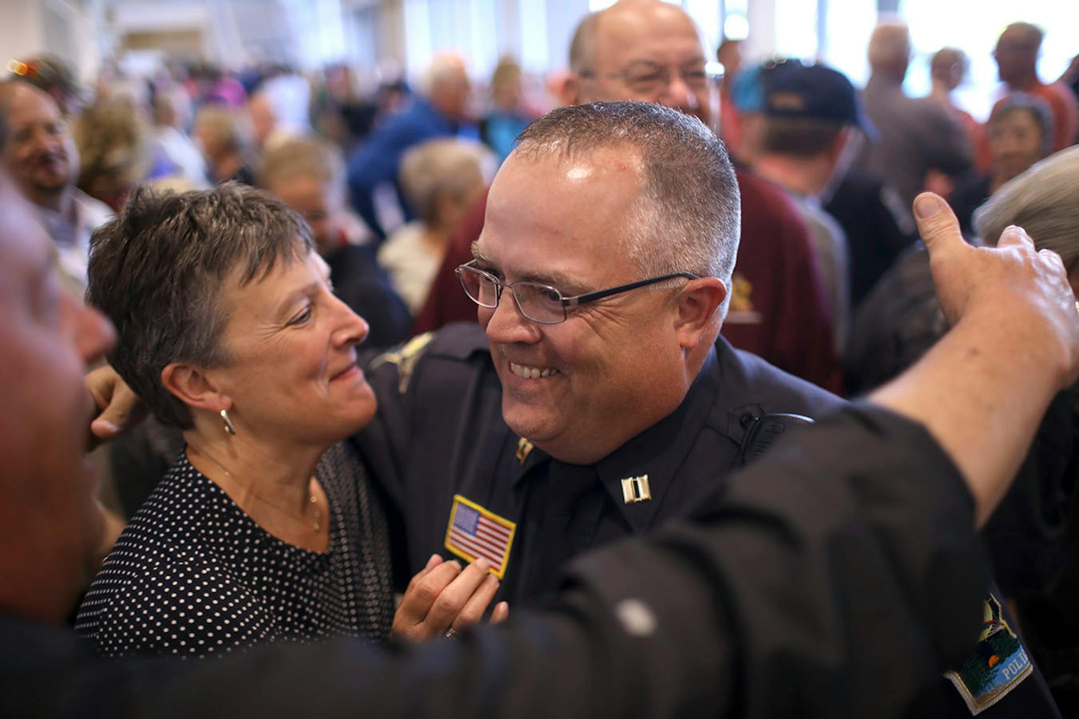 Forest Lake Police Capt. Greg Weiss was congratulated by Forest Lake Schools Superintendent Linda Madsen as he left the city council chambers after their vote to approve a contract with the police force.