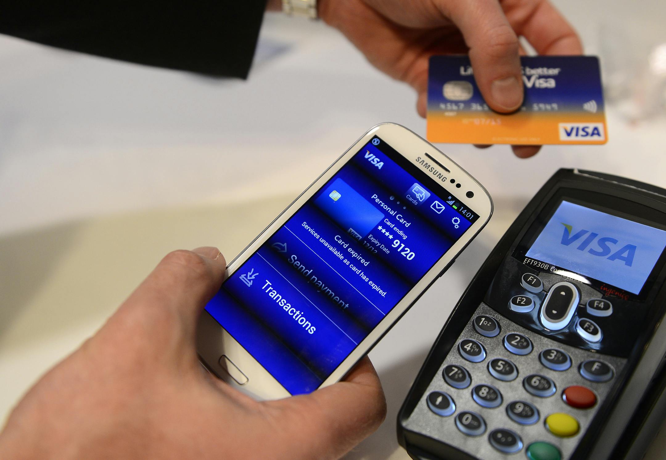FILE - In this Wednesday, Feb. 27, 2013, file photo, a man uses the NFC payment Visa system at the Mobile World Congress, the world's largest mobile phone trade show, in Barcelona, Spain. Payment processing giant Visa is launching a platform to allow banks to integrate various types of biometrics, such as your fingerprint, face, voice, etc., into approving credit card applications and payments. It could lead to customers having to take a selfie to verify they actually made an online purchase or